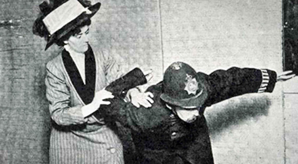 Edith Garrud demonstrerar sin ”suffrajitsu”. Garrud organiserade en  försvarsgrupp, ”The Bodyguard”, till skydd för Emmeline Pankhurst och andra suffragetter från polisvåld. Ofta gömdes träklubbor och andra vapen innanför kläderna.