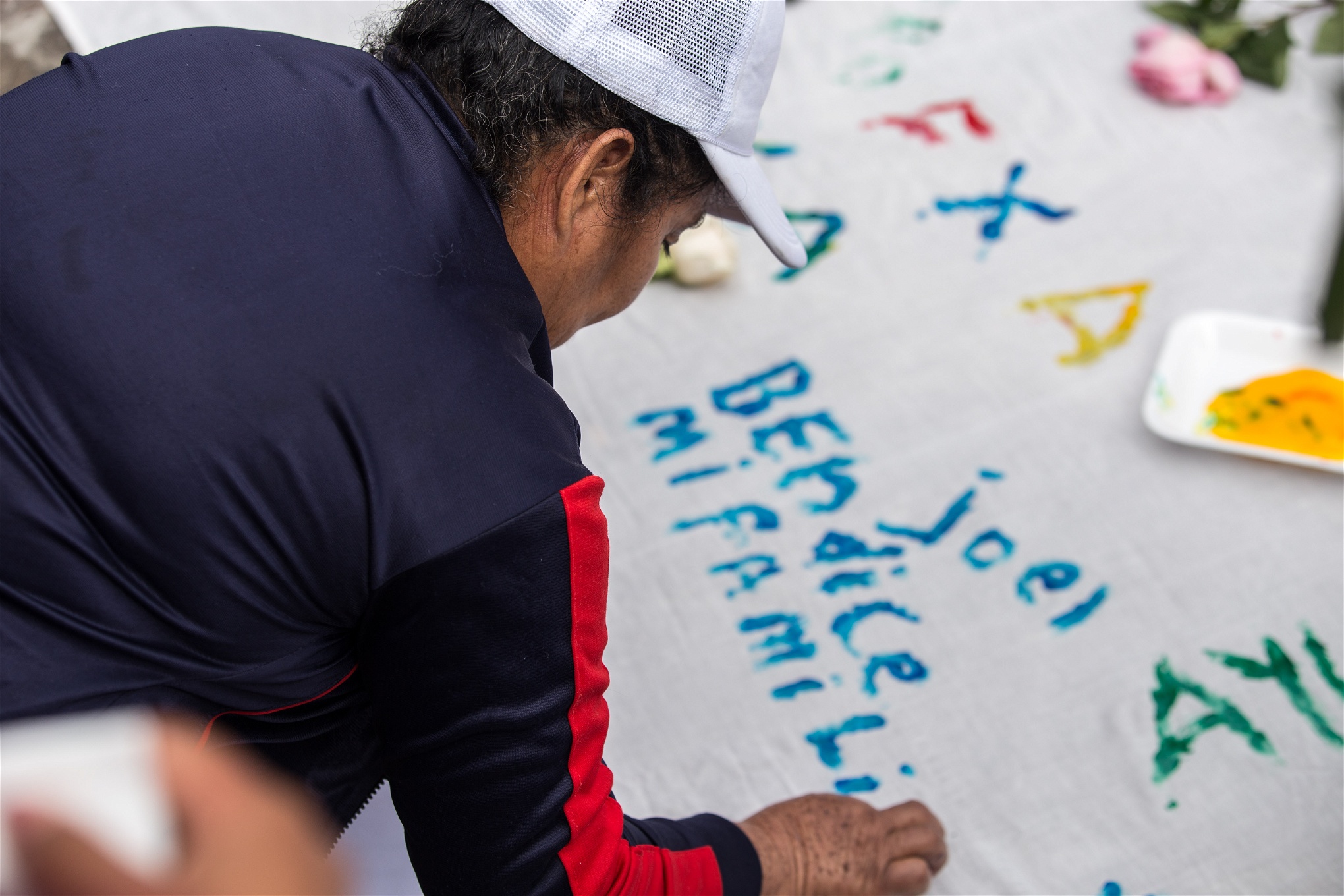 En av mödrarna ber sin son Joel att välsigna hennes familj, genom att skriva på en flagga som de ska överräcka till Guadalupe.
