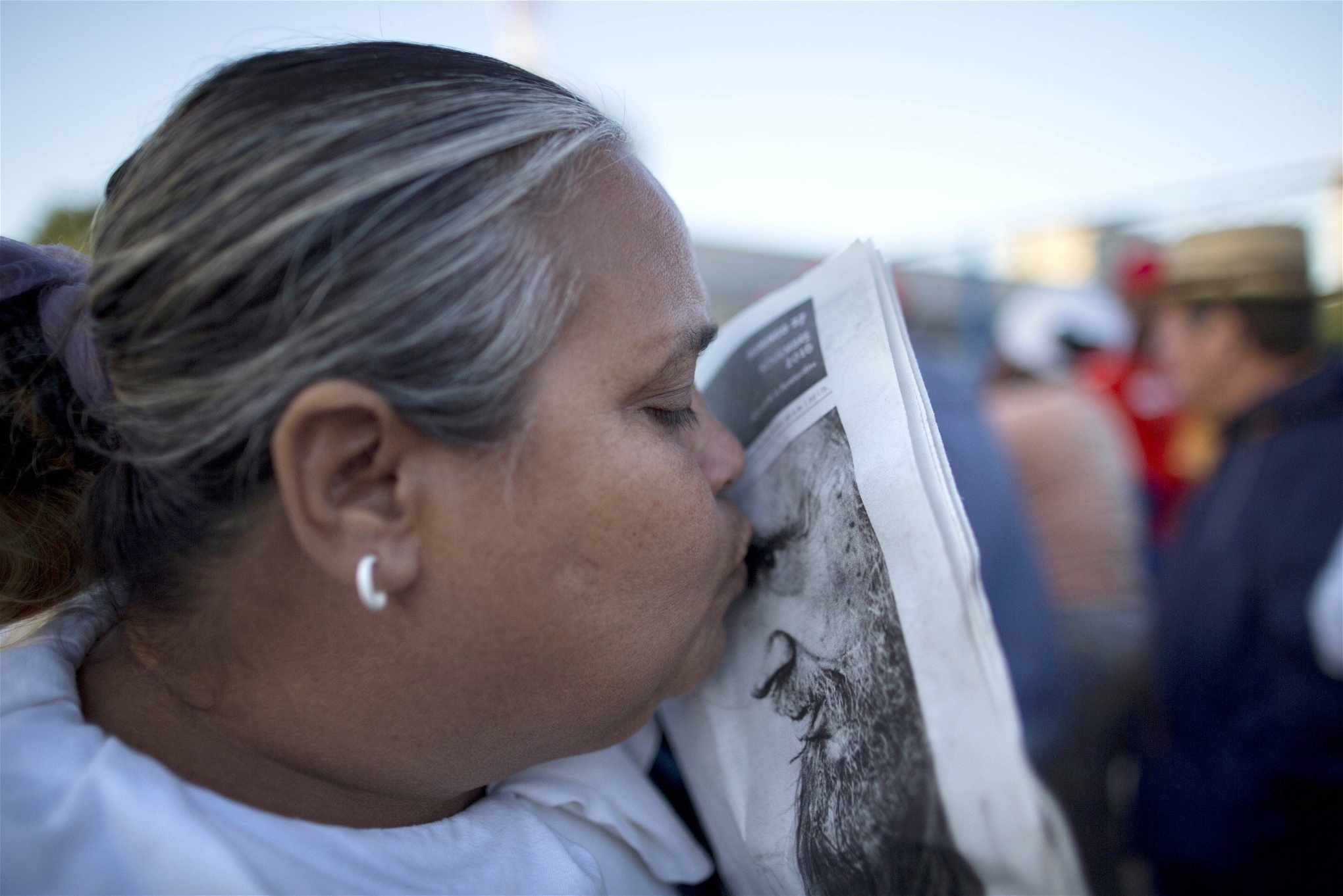 En kvinna kysser en bild av Fidel Castro medan hon väntar i kön för att komma in på revolutionstorget för ett veckolångt farväl av mannen som ledde Kuba under nästan ett halvt sekel.