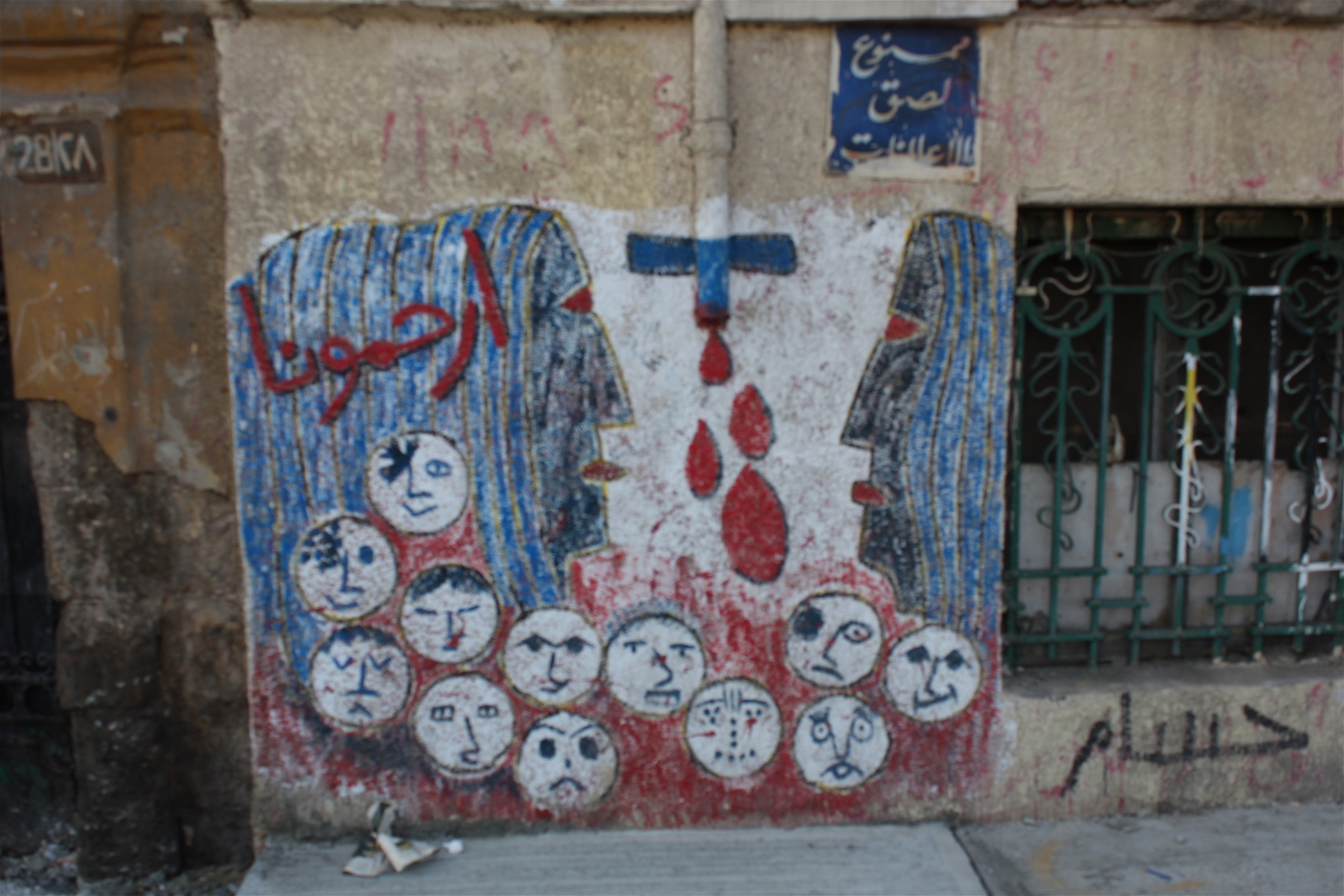 ”Visa oss nåd”, står det över ansiktena på denna målning i centrala Kairo.