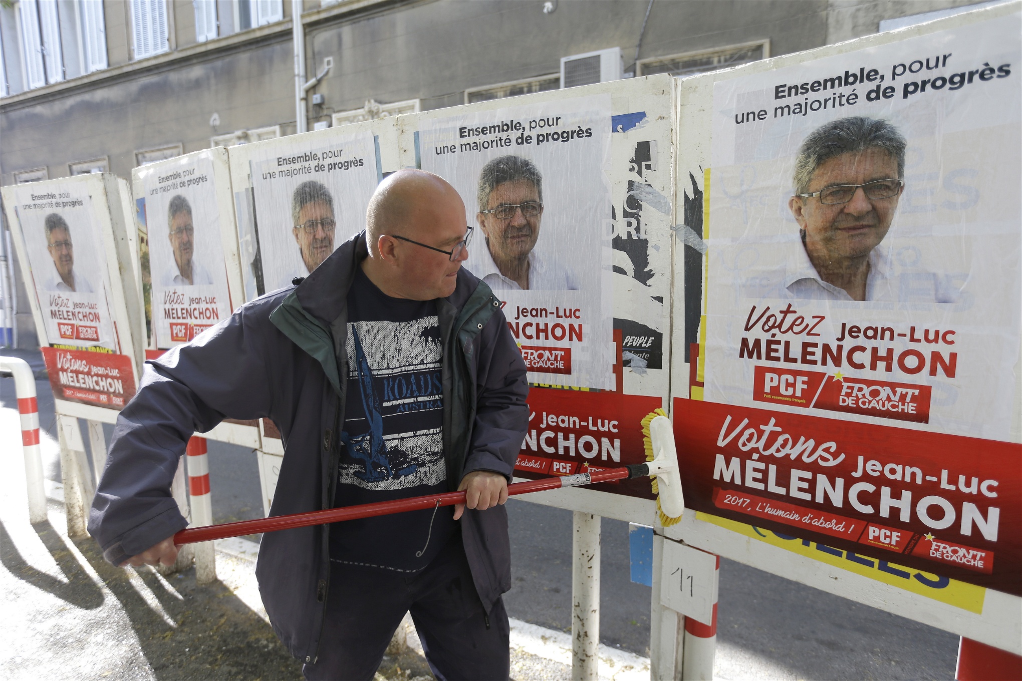 En Melenchón-supporter klistrar upp valaffischer i Marseille.