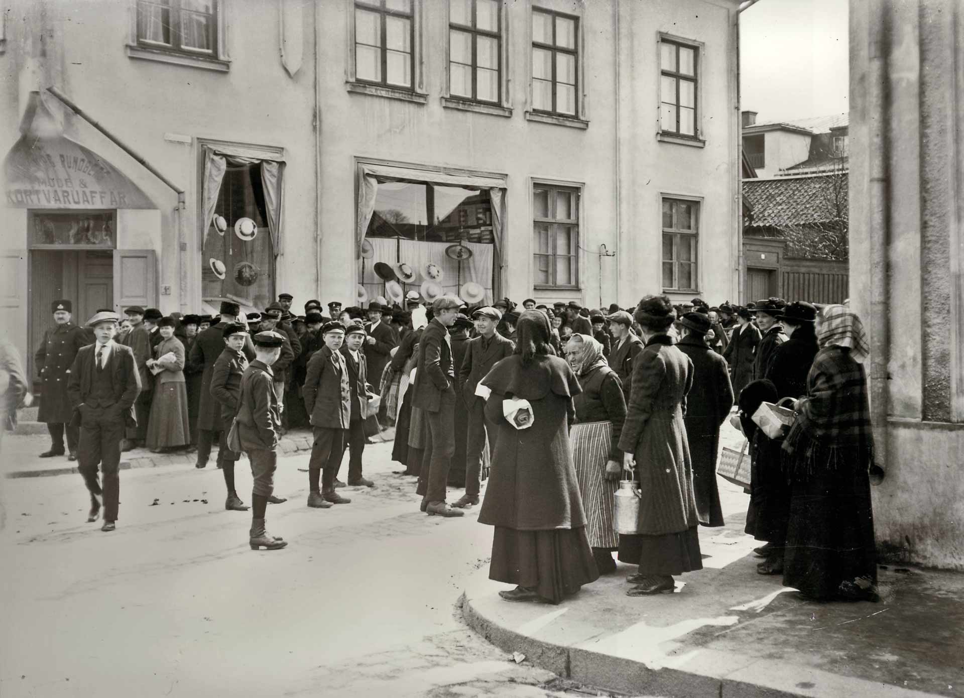 Människor i kö för att köpa oransonerat paltbröd eller potatis i hörnet av Storgatan-Bredgatan i Västervik.