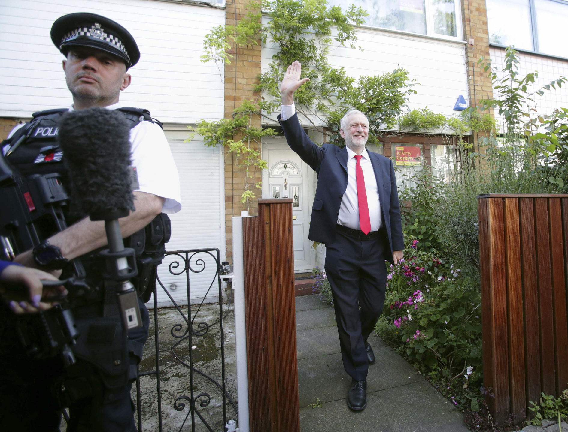 Labours ledare Jeremy Corbyn vinkar glatt när han lämnar sitt hem i norra London på fredagsmorgonen. Han uppmanar Theresa May att avgå efter hennes valförlust.