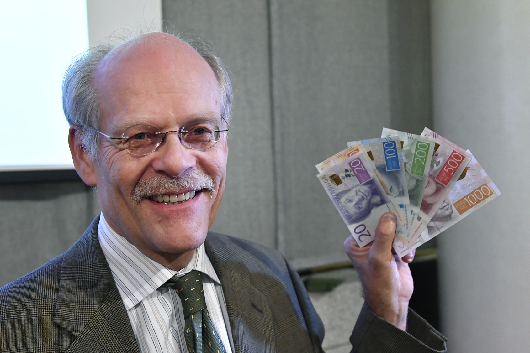 Riksbankens chef Stefan Ingves visar upp Sveriges nya mynt och sedlar. Men vad händer när ingen vill ta emot kontanterna?