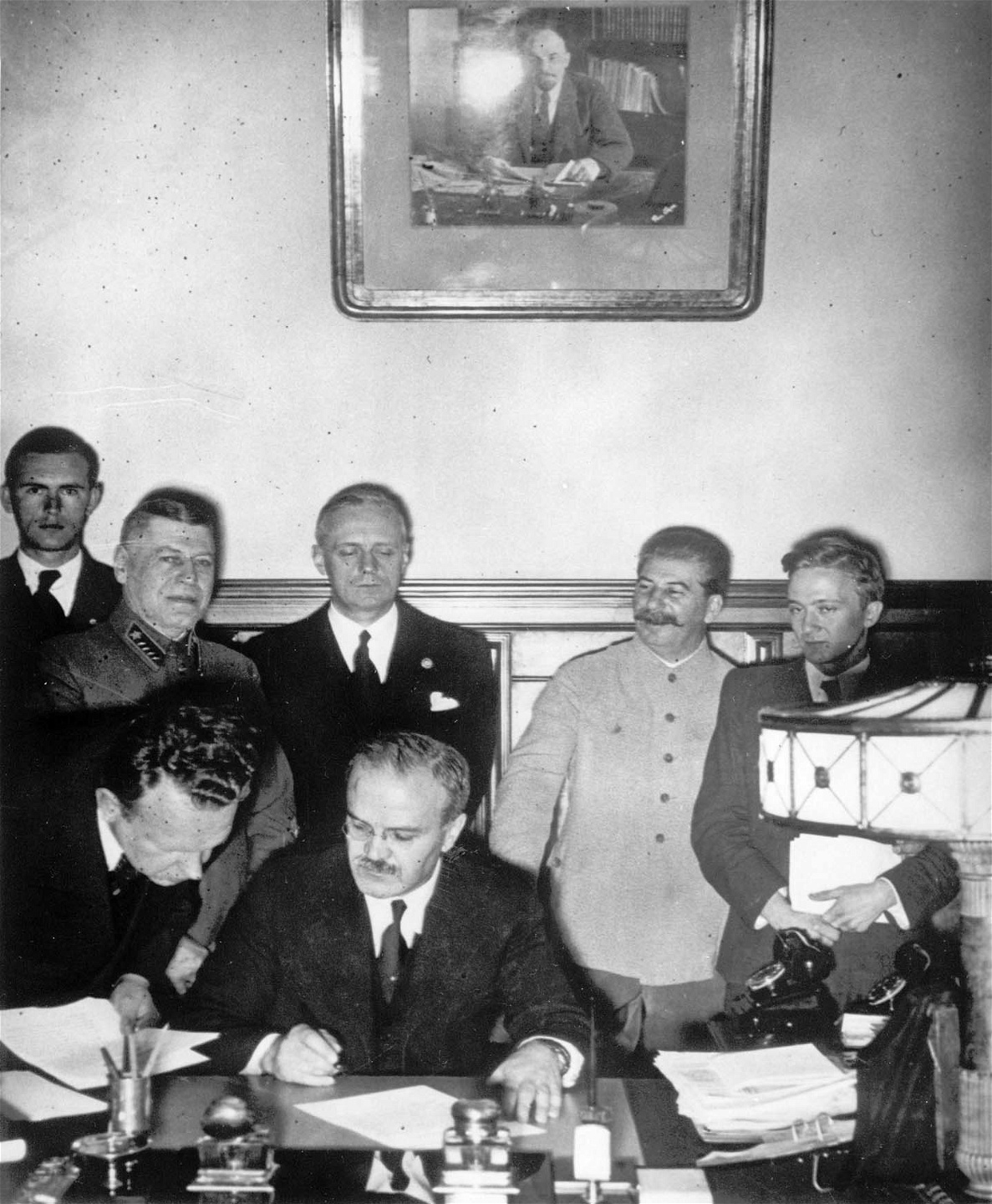 Sovjetunionens utrikesminister Molotov undertecknar ickeaggressionspakten
mellan Tyskland och Sovjetunionen den 23 augusti 1939, ett par
dagar före utbrottet av andra världskriget. Bakom honom Tysklands
utrikesminister Joachim von Ribentrop längst till höger, och Stalin bredvid.
