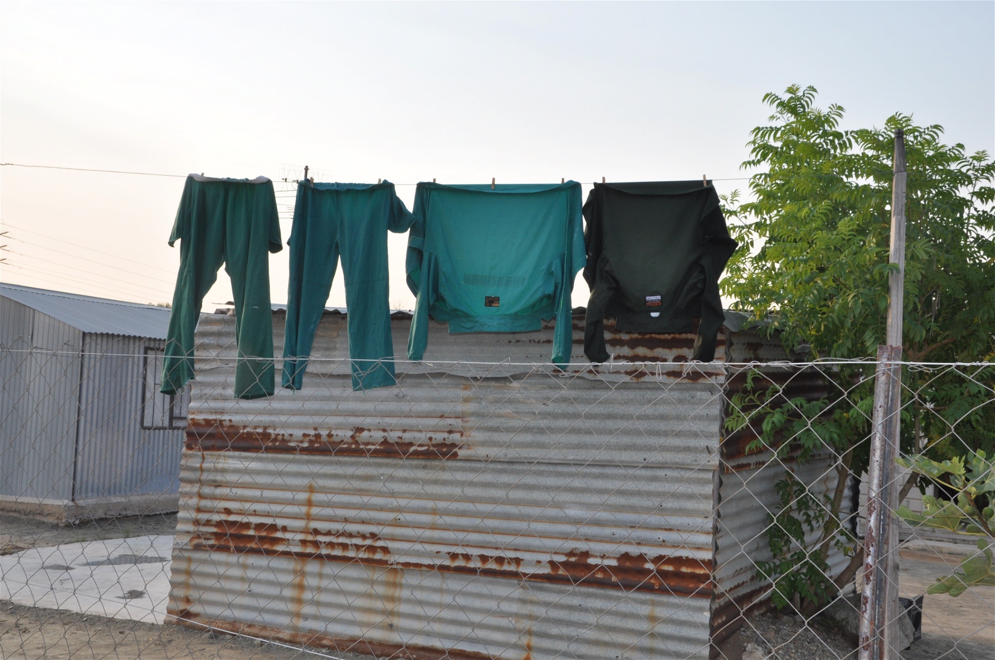 Mellan plåtskjulen i den informella bosättningen Won­der­kop hänger Lonmins gröna arbetsoveraller på tork.