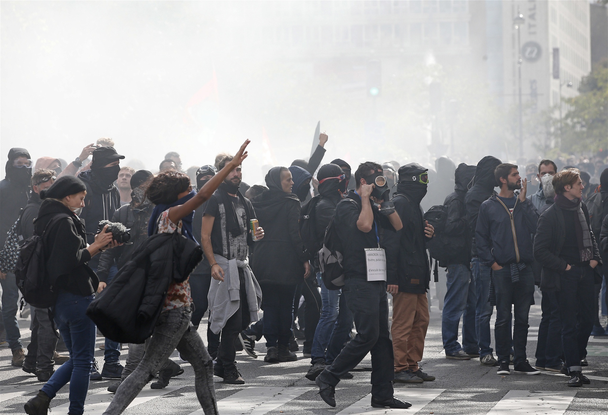 Demonstranter gör tecken efter sammandrabbningar med polisen under protestmarschen i Paris på tisdagen.