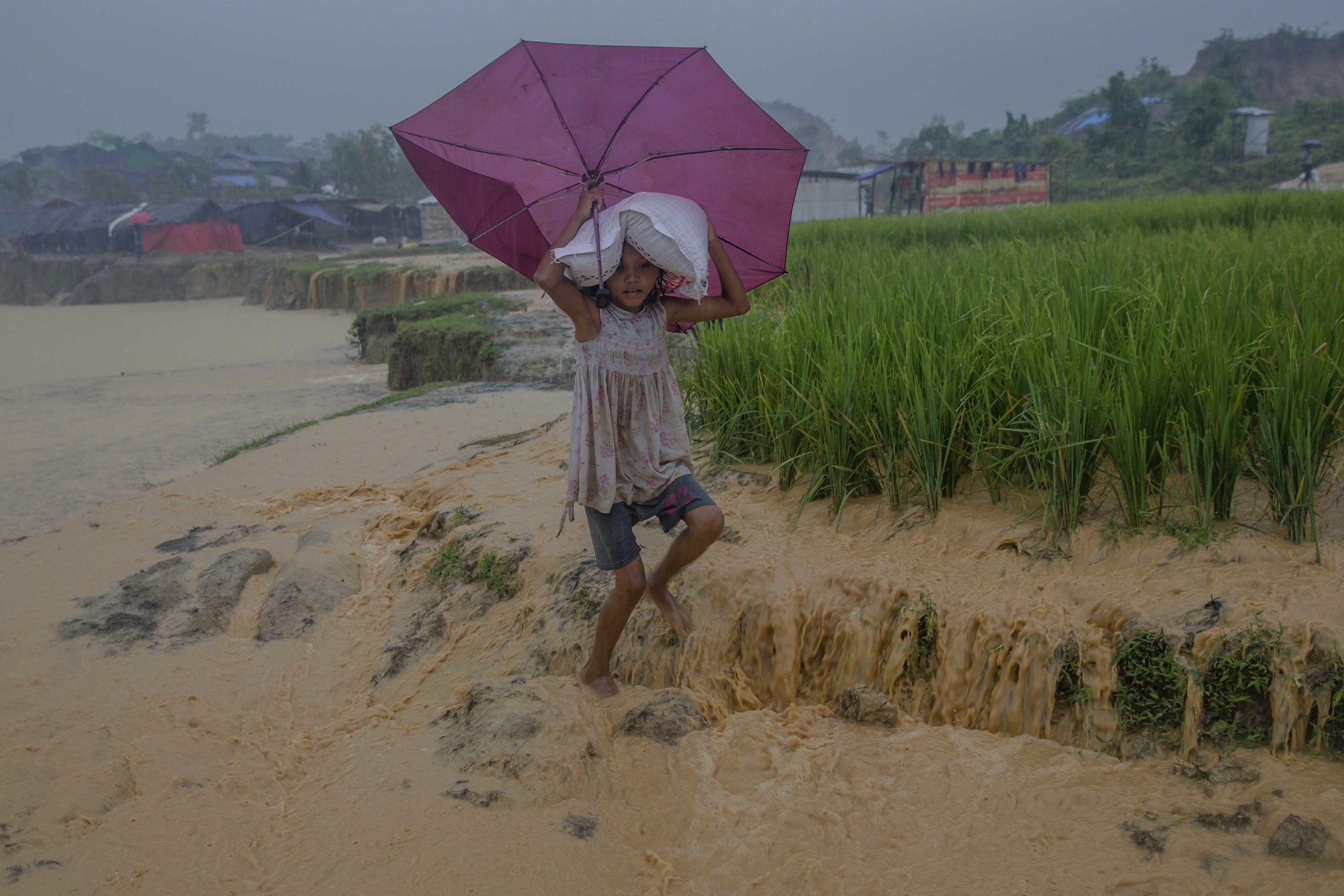 Saira Begum som tillhör minoriteten rohingya bär en säck med mat från en hjälpsändning i ett flyktingläger i Cox's Bazar i Bangladesh.