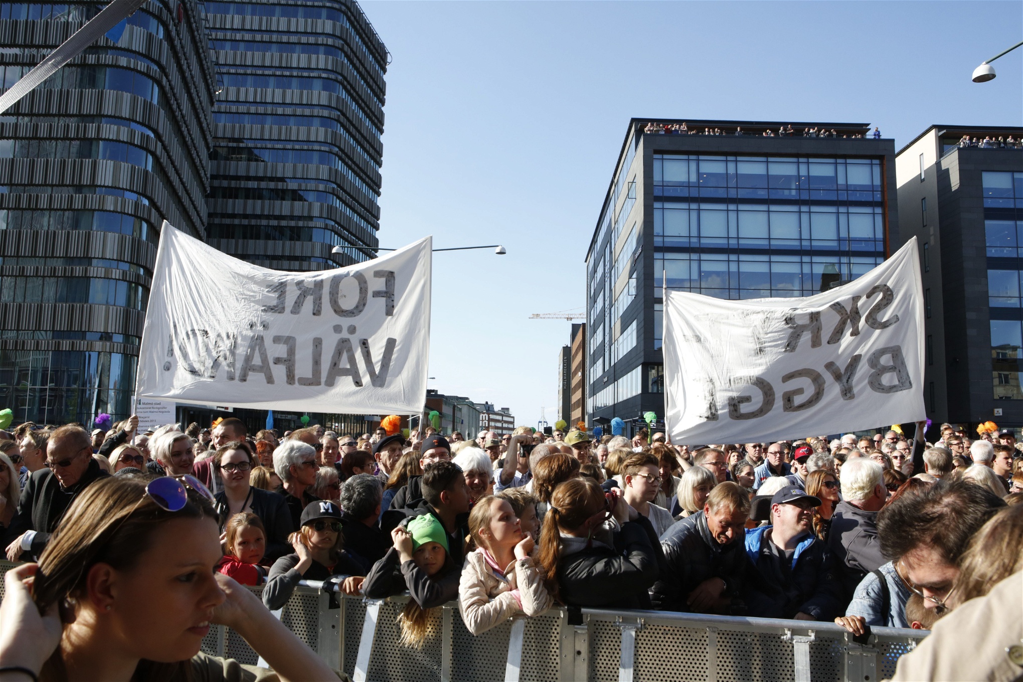 Demonstranter håller upp banderoller med texten ”Skrytbygge – Före välfärd” under invigningen av Clarion Hotel & Congress Malmö Live 2015. 