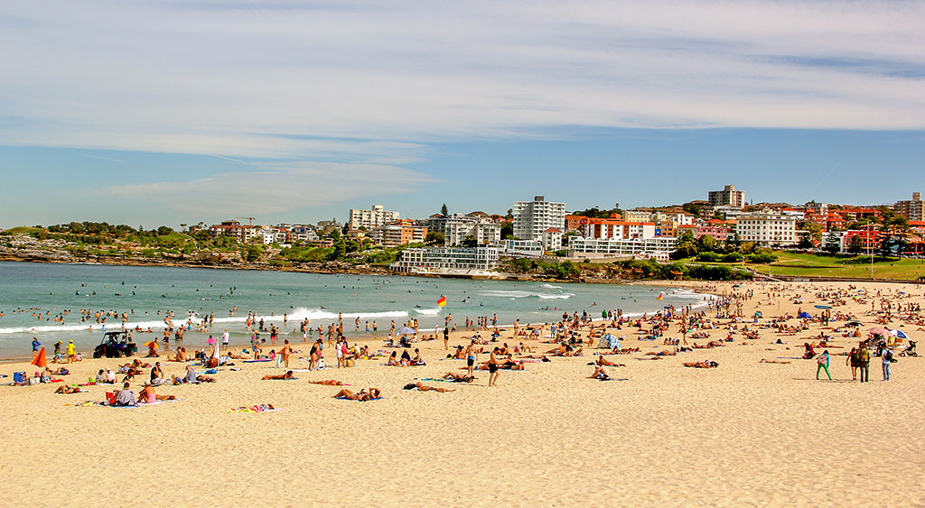 Bondi Beach, i östra Sydney. En dröm för asylsökande, och en stark kontrast till verkligheten för människorna som förösker kämpa sig i land på båtar. 
Föregående uppslag: September 2009. En båt med 48 ”misstänkt asylsökande” människor siktas av Australian Customs and Border Protection drygt 14 mil utanför Australiens kust. 