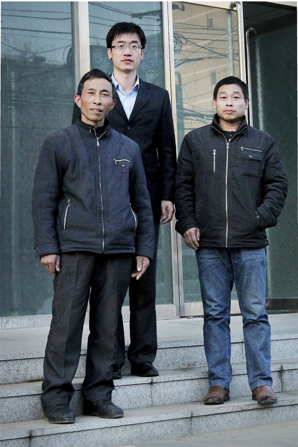 Wang Dan (mitten) arbetar på advokatbyrån Zicheng public interest lawyers och bistår bland andra Dong Dajie (vänster) och Ma Fangshou som driver juridiska processer mot sina tidigare arbetsgivare.