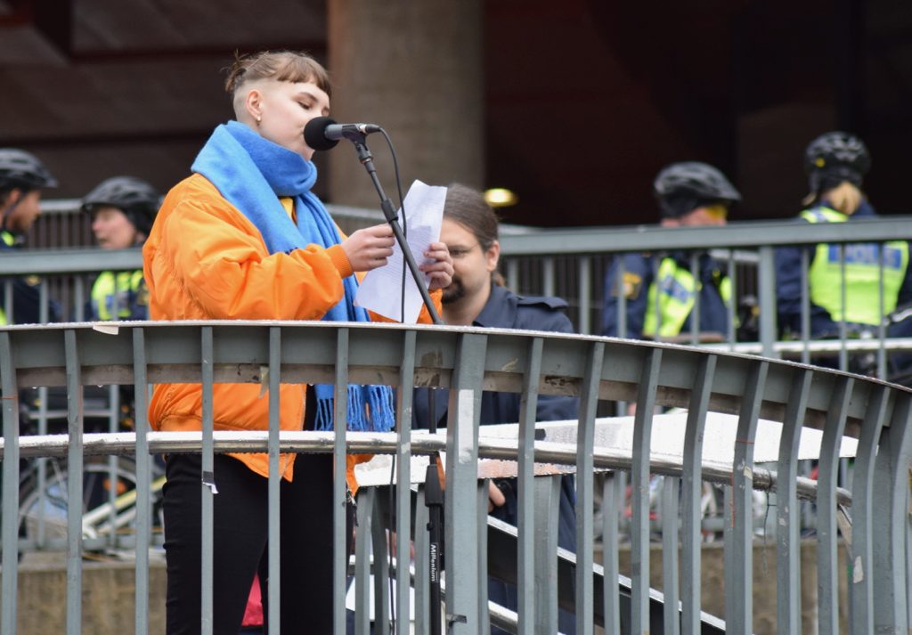 Linnea Bergmark från Syndikalistiska Ungdomsförbundet, SUF, förstamajtalar på Sergels torg i Stockholm.