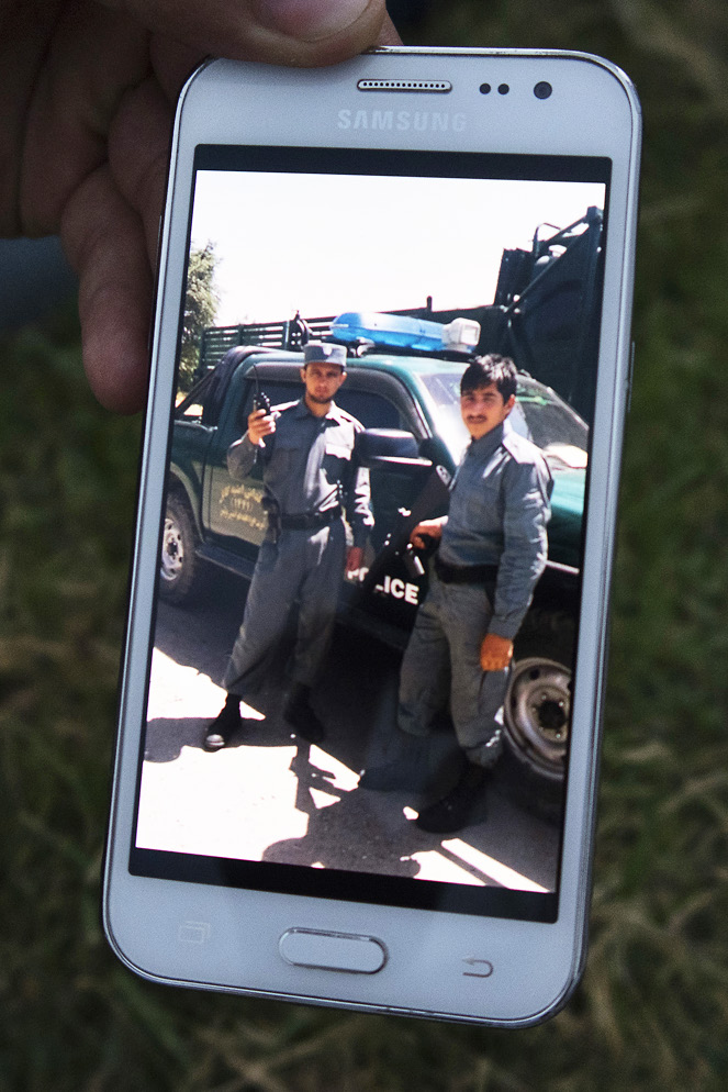 Kamal Stanikzai visar bilder från sin tid som afghansk polis.