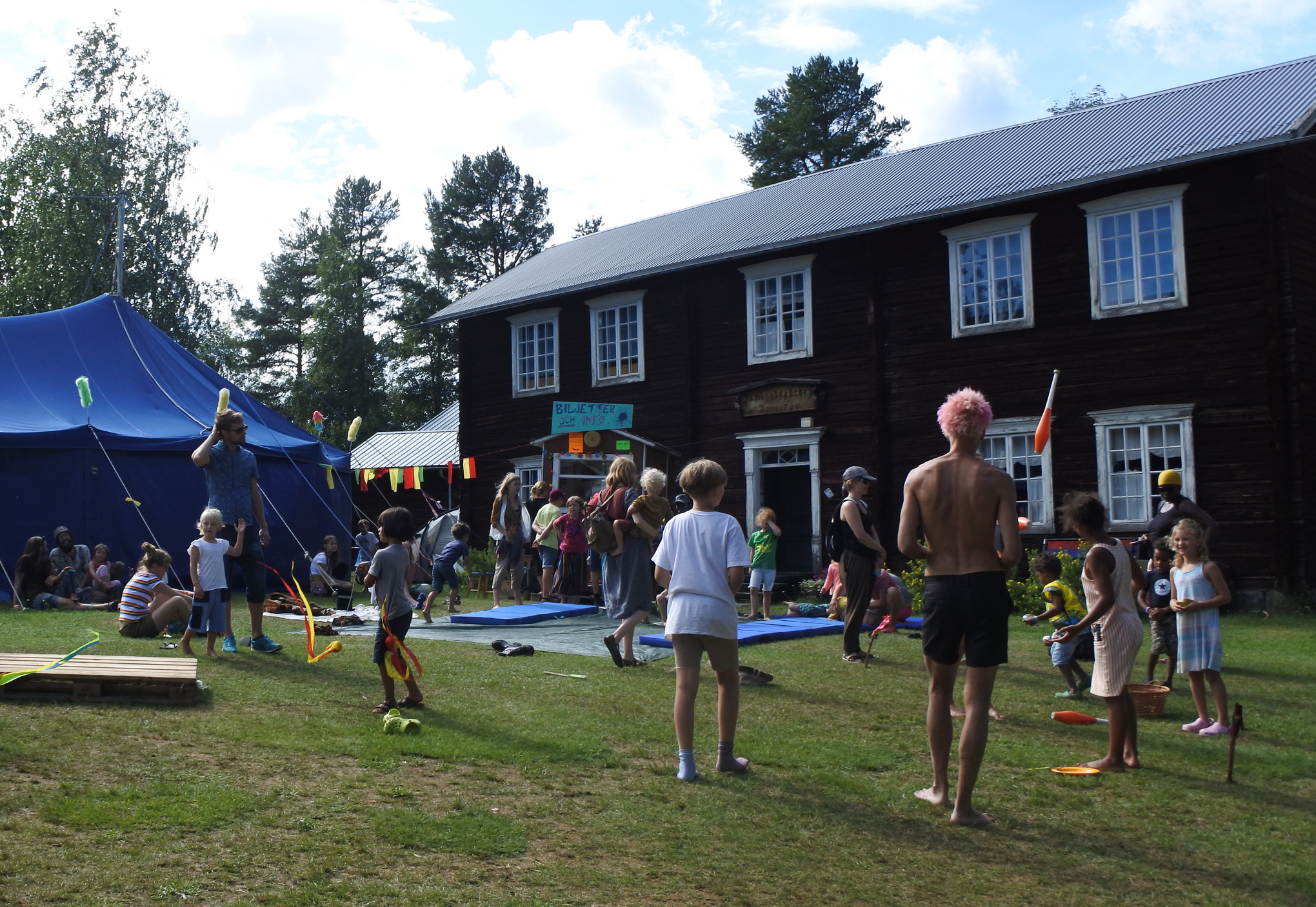 Prova-på-cirkus för barn på gräsmattan framför hembygdsgården och festivalens cirkustält.