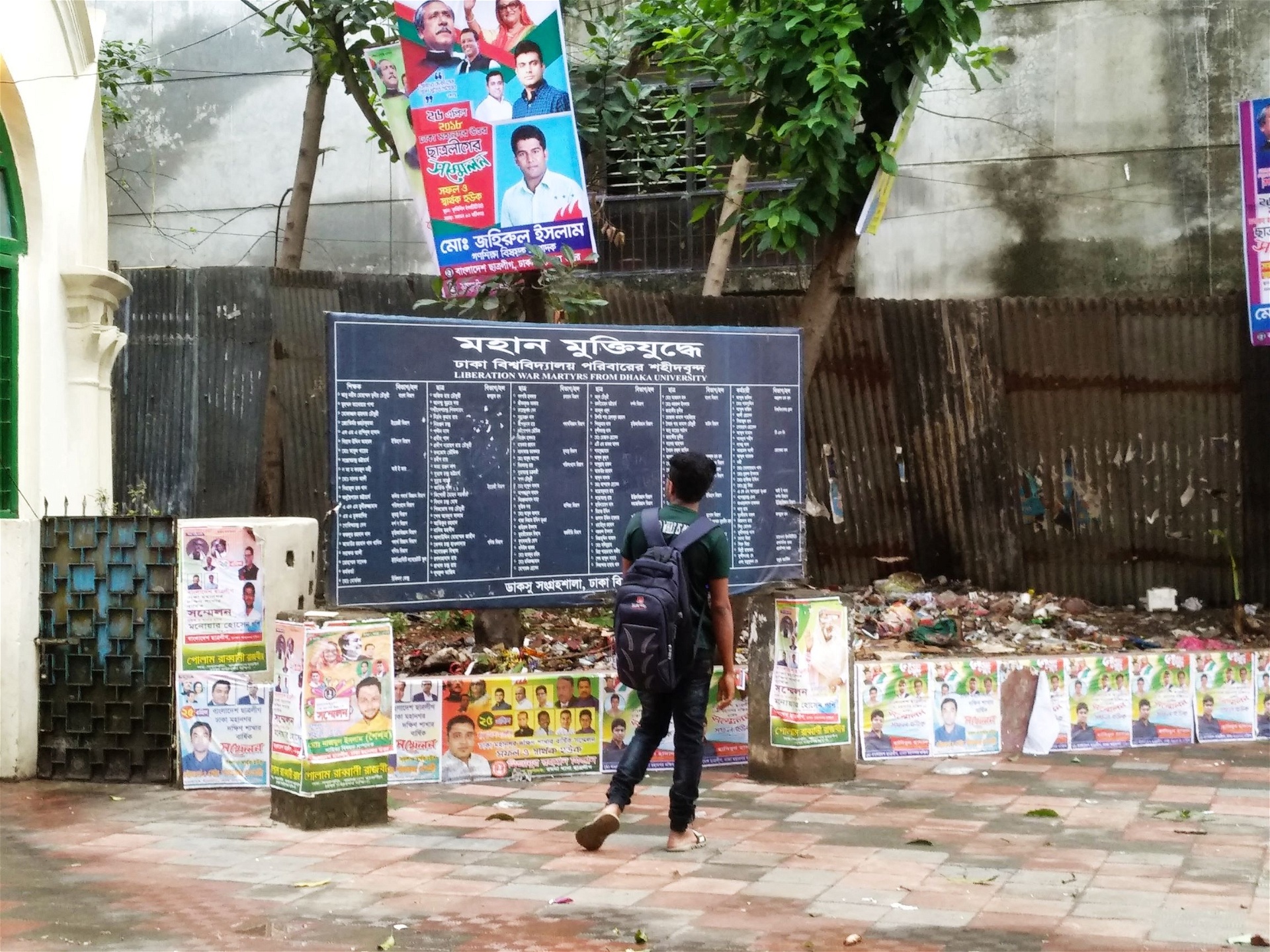 En student vid en tavla vid Dhakas universitet som listar namnen på personer som deltog i kriget för Bangladeshs frigörelse 1971. Nu menar kritiker att en ny lag går emot kärnan i den kamp som ledde fram till självständigheten från det dåvarande Västpakistan. 