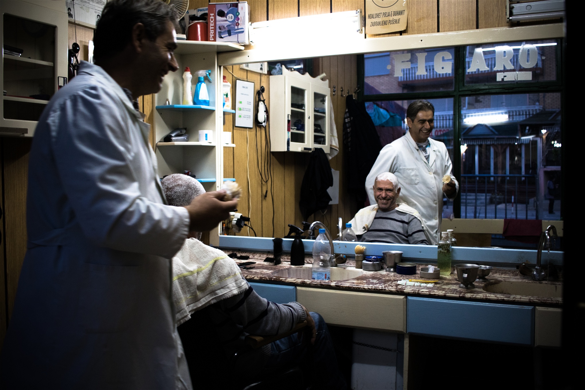 Fadil Junuzi klipper kunden Osman Hajrollahu i sin frisersalong i Presevo.