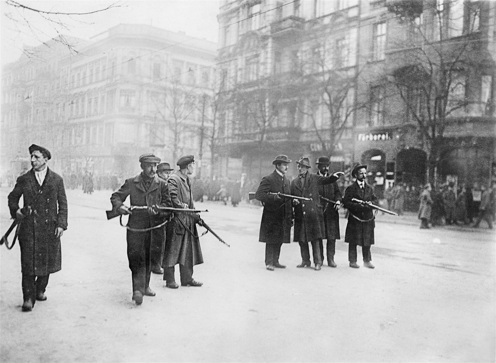 Spartakister håller en gata i Berlin som ett led i det revolu­­tionära skeendet. Den 5 januari 1919 besattes offentliga bygg­­­­nader, järnvägsstationer och de stora tidningarna, inklu­sive SPD-­­trogna Vorwärts, och redaktionerna skickades iväg under vapenhot.