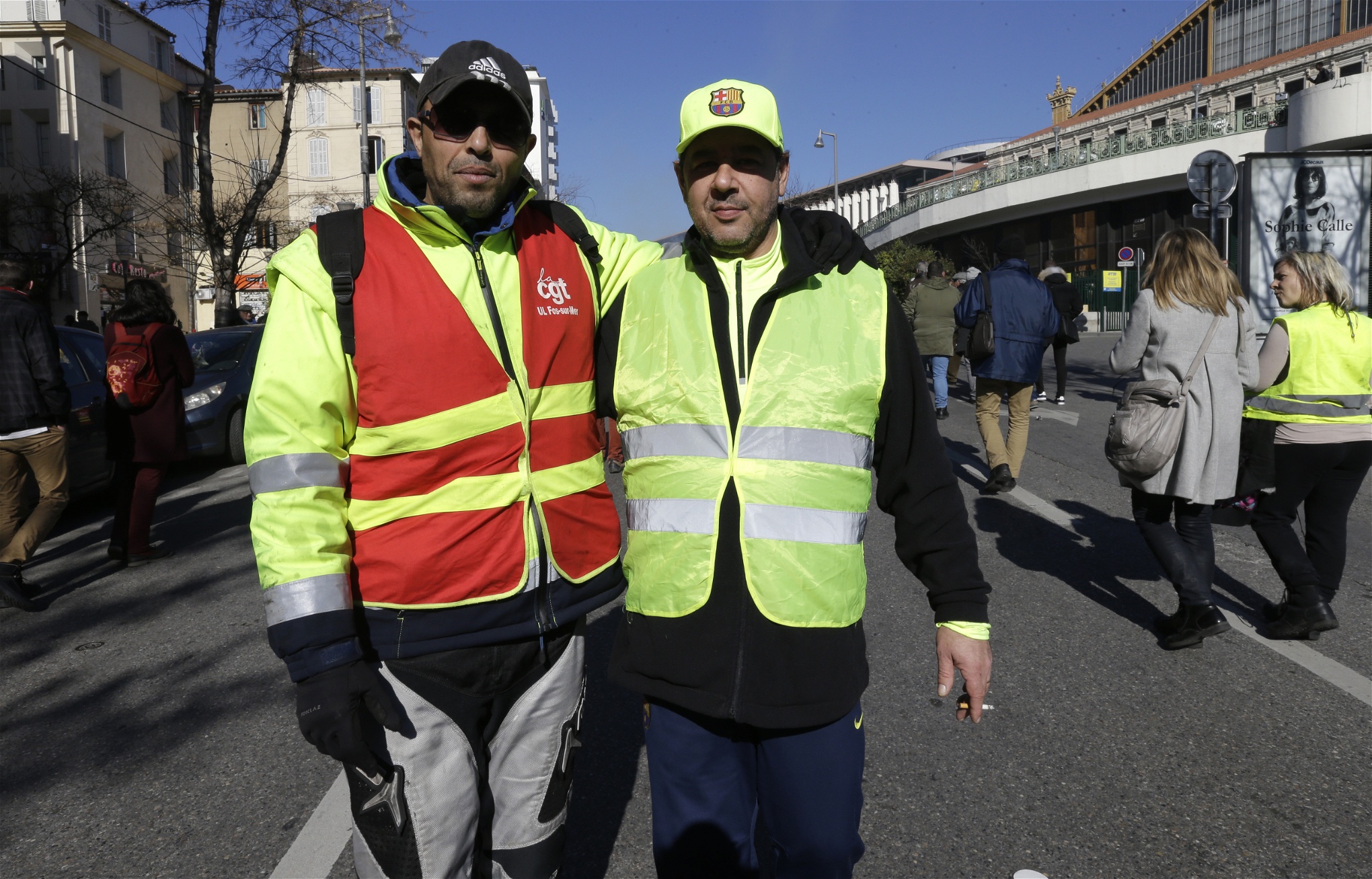 Mourad från CGT och Daniel från Gula västarna poserar tillsammans under en demonstration i Marseille i samband med den franska strejken tisdagen den 5 februari.