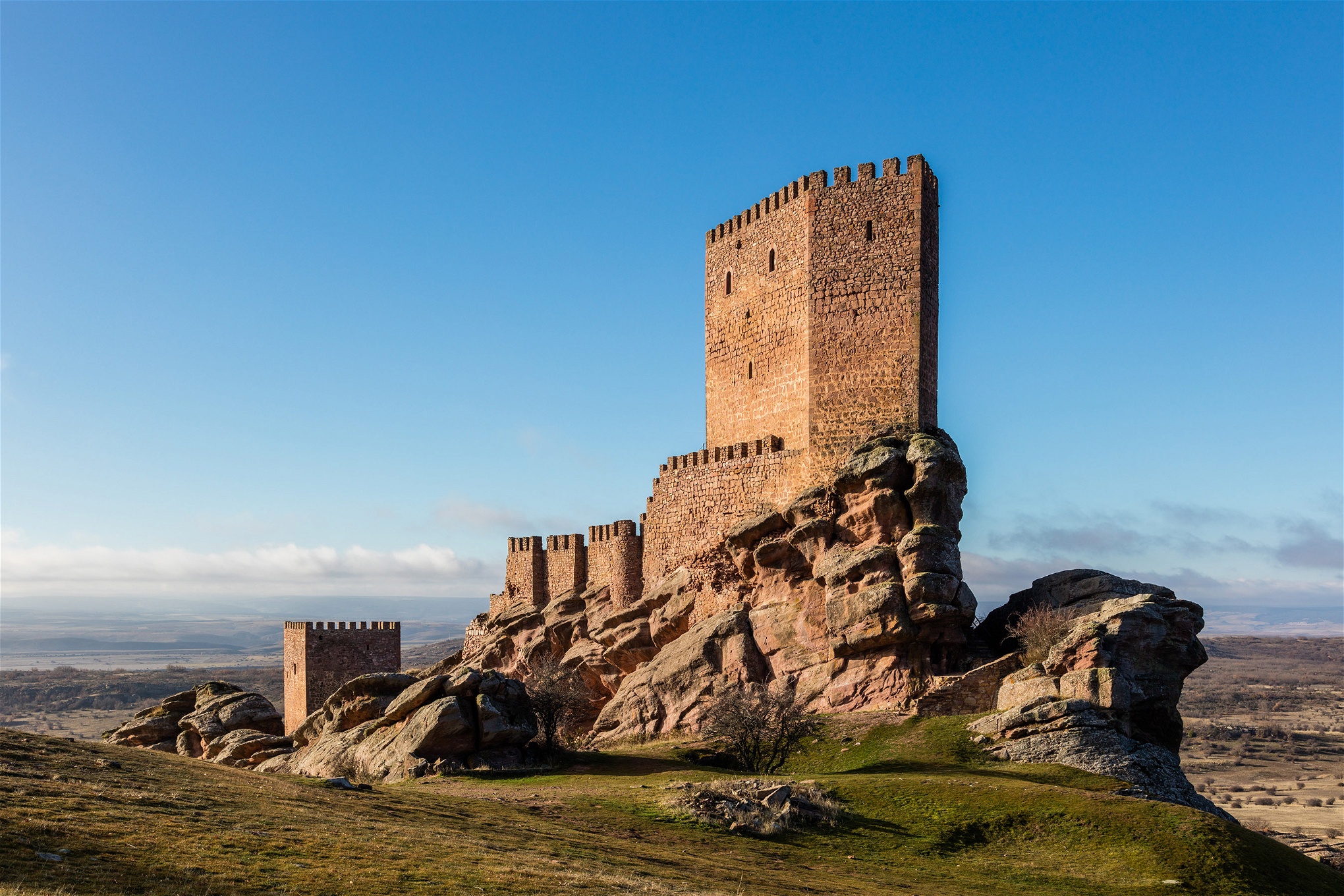 Castillo de Zafra i Spanien är en av inspelningsplatserna för Game of Thrones. Samhällsordningen i serien kan liknas vid ett medeltida vasallsystem, där furstendömena i utbyte mot beskydd ställer soldater till kungarikets förfogande.