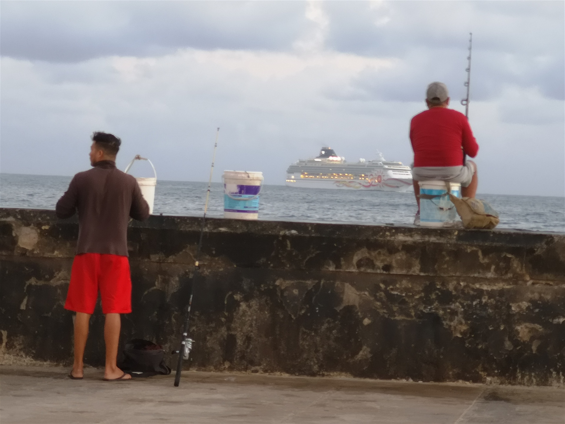 Fiskare i Havanna. Ute på redden ligger en lyxkryssare med turister.