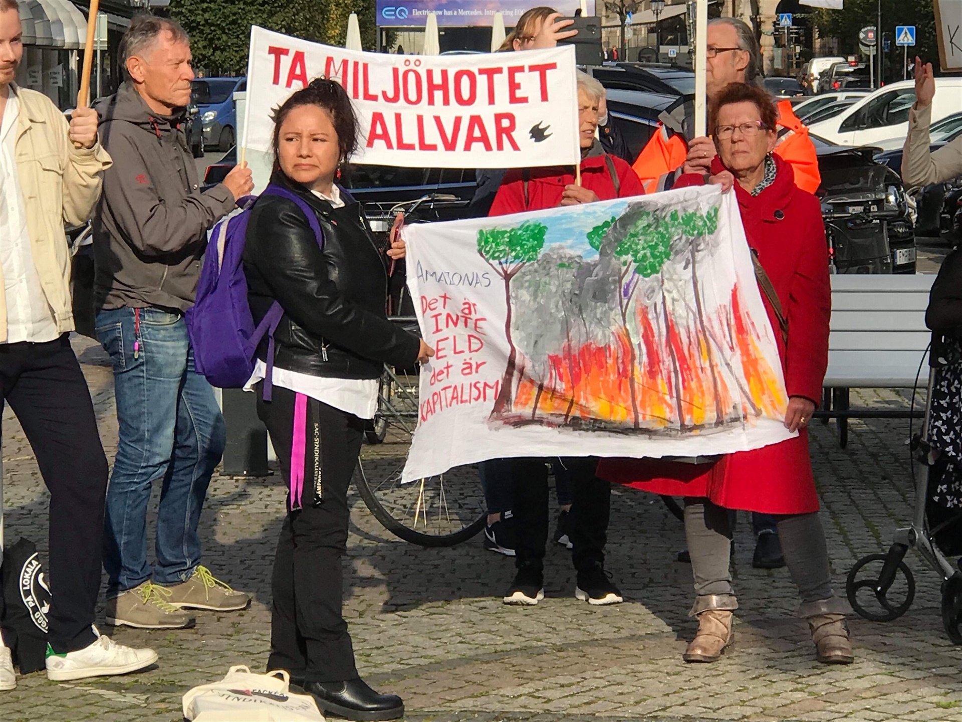 Claudia Velásquez håller upp en nymålad banderoll.