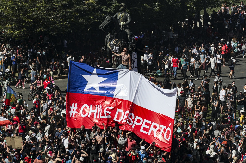 Demonstranter i Santiago reser en flagga med texten ”Chile vakna