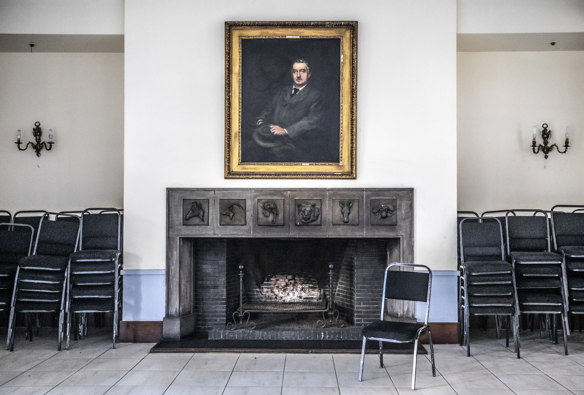 På Harare Club, en gång i tiden ett vattenhål för den vita eliten i Rhodesia, blickar Cecil Rhodes ner från en vägg.