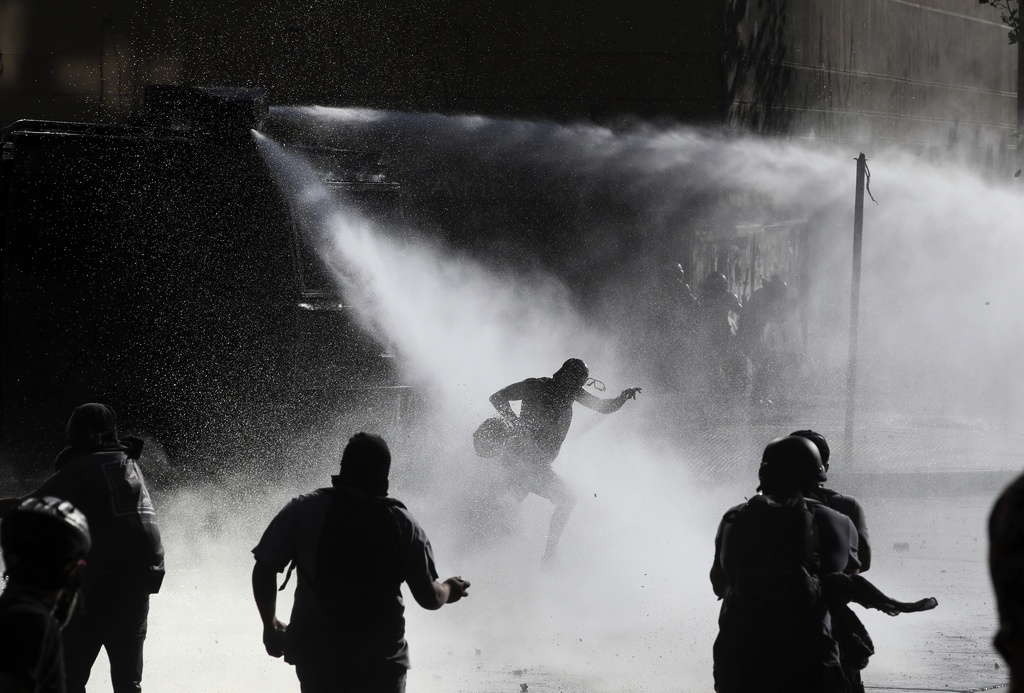 Chilensk polis använder vattenkanoner mot regimkritiska demonstranter i Santiago i januari. 