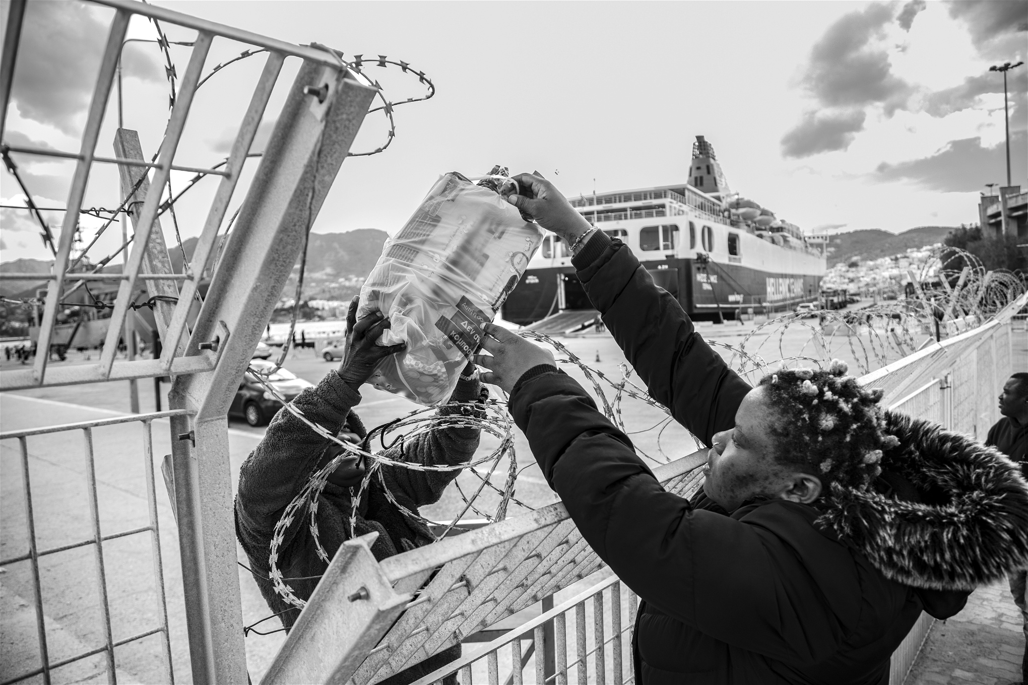 Foto: Valerio NicolosiSelma lämnar över vatten och mat till nyanlända som sitter fast i hamnen.