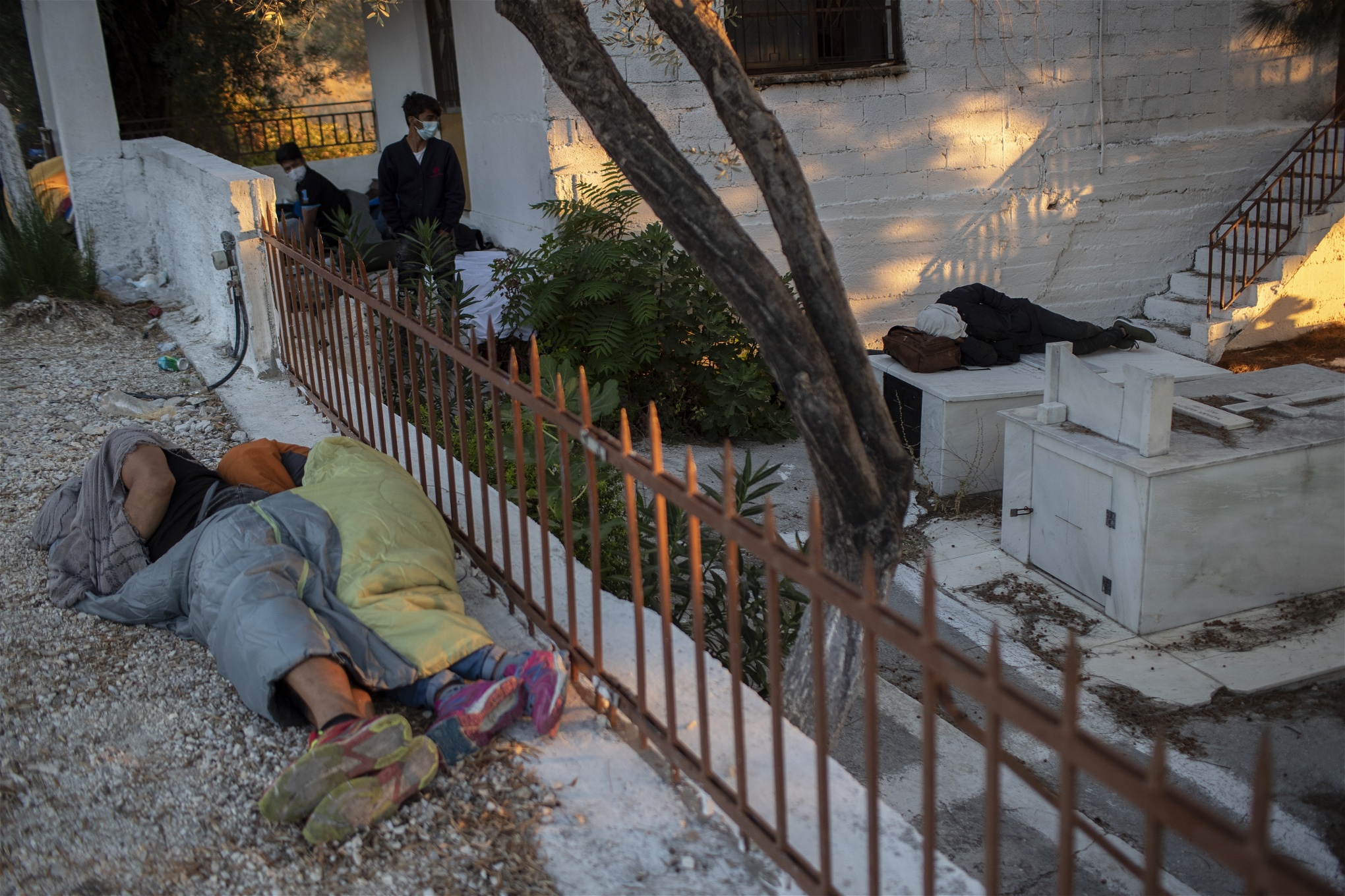Migranter sover vid en kyrkogård nära Mora på torsdagen efter branden. Foto: Petros Giannakouris/TT
