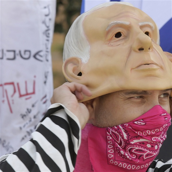 En demonstrant i Israel bär en gummimask föreställande premiärminister Benjamin Netanyahu.