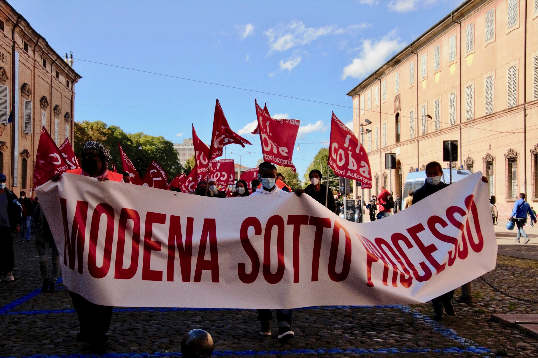 Foto: Alessandra MinconeAnställda på Italpizza demonstrerar med banderollen "Modena inför rätta".