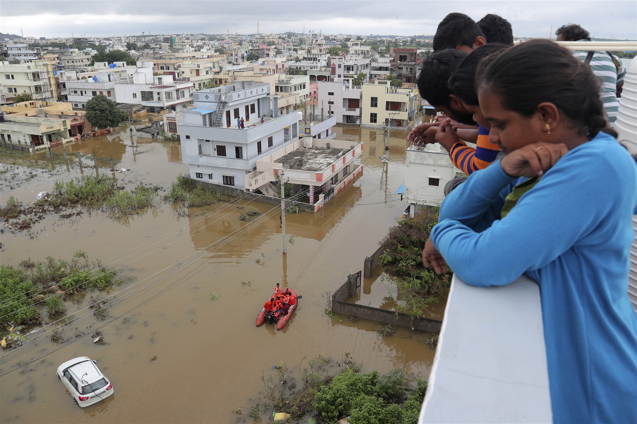 En familj tittar på förödelsen som orsakats av översvämningarna i Indien.