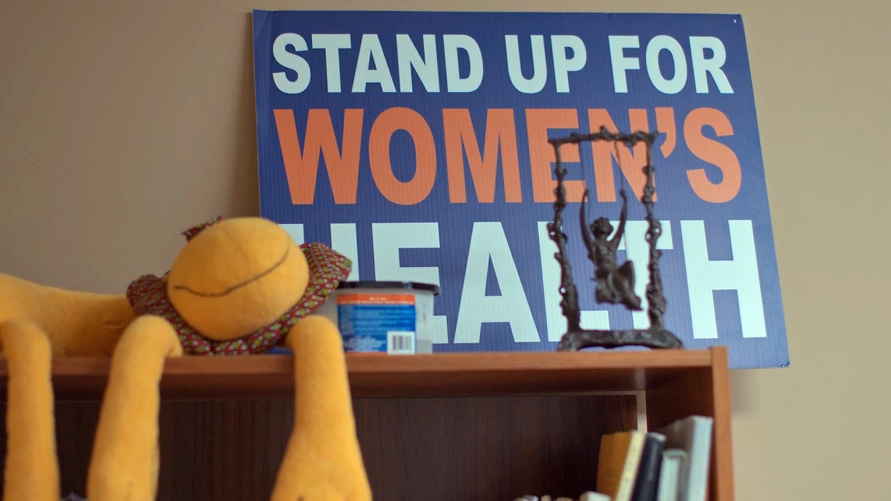 En skylt på en abortklinik där det står "Stand up for women's health.
