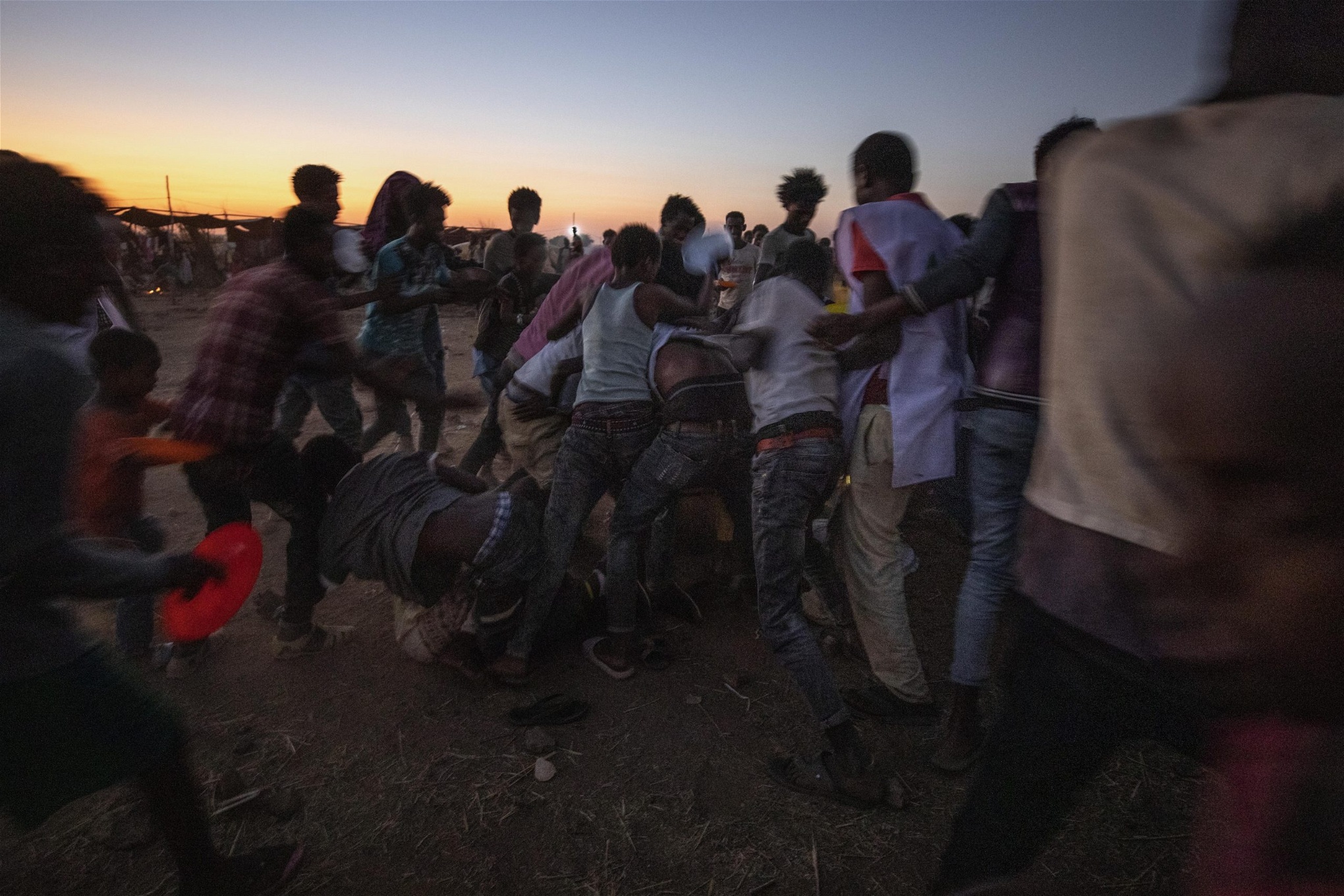 Tigrianska män slåss för att få tag i kokt ris vid en matutdelningn i flyktinglägret Umm Rakouba i östra Sudan. Foto: Nariman El-Mofty/AP/TT
