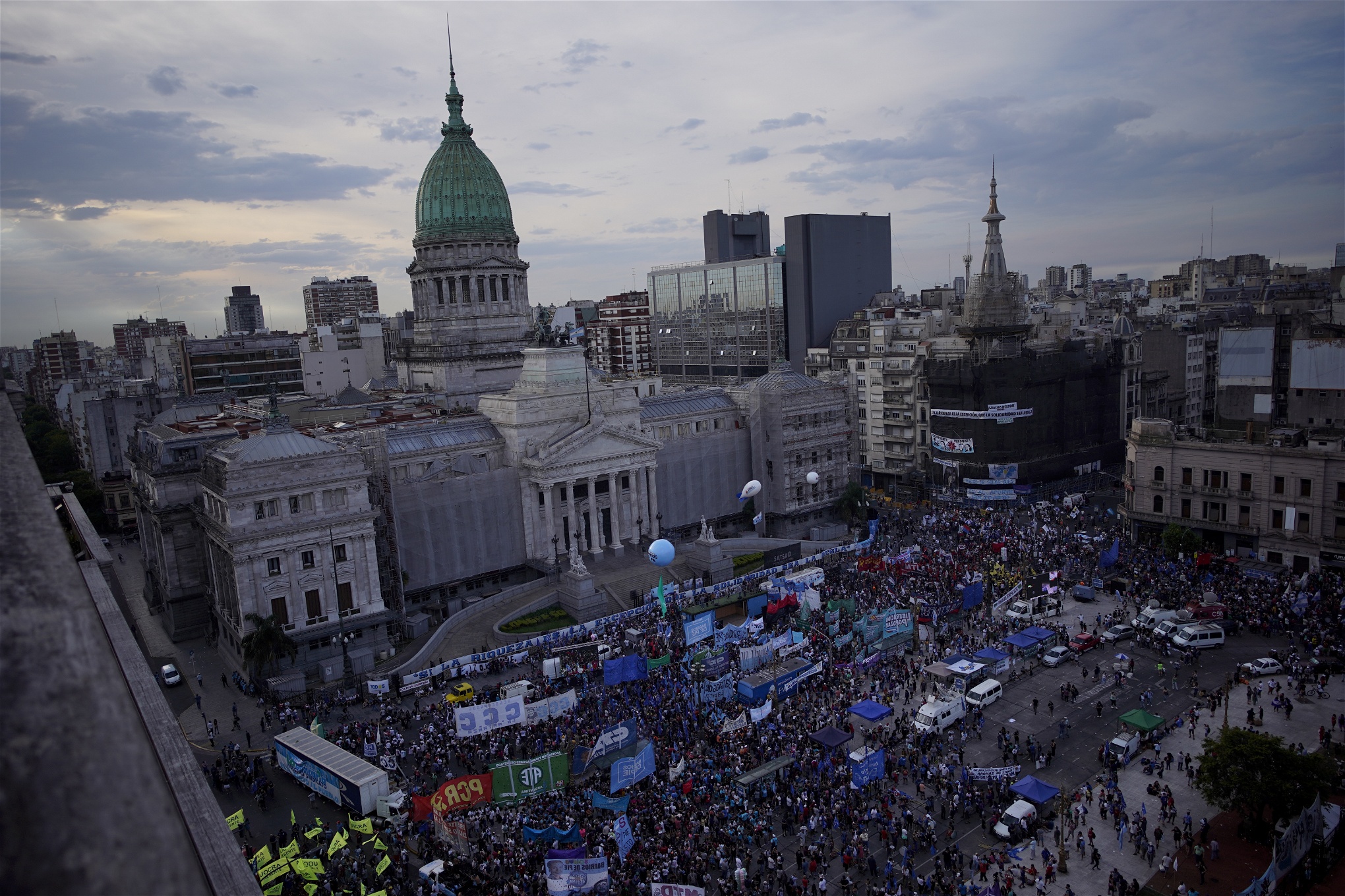 Flygfoto över torget framför den argentinska kongressen. Torget är fyllt av demonstranter med skyltar och ballonger.