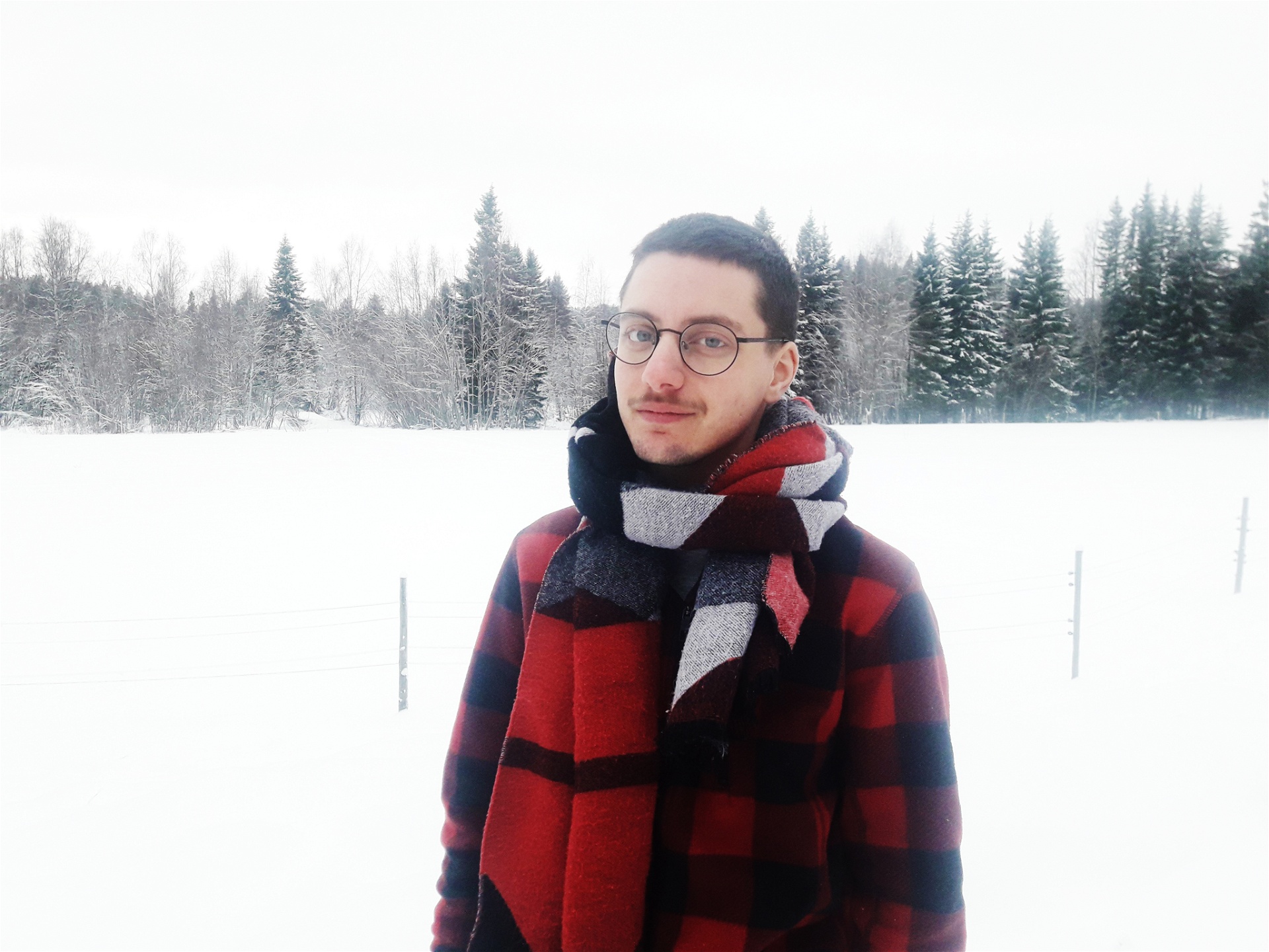 Nino Mick fotograferad i ett snöigt landskap med en stor halsduk runt halsen.