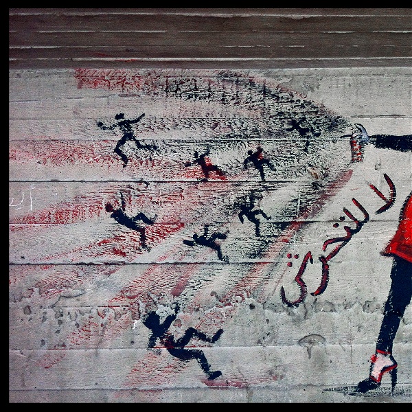Väggmålning med kvinna i rött som sprayar med en sprayburk.