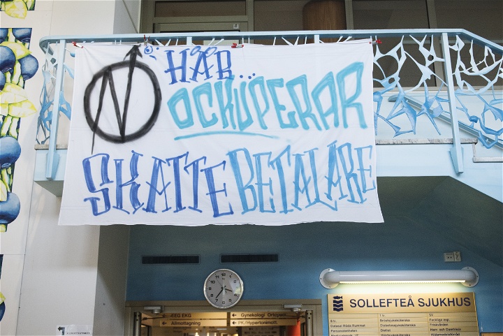 Bild på en vit banderoll med texten Här ockuperar skattebetalare.