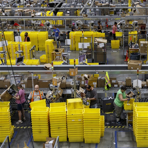 Översiktsbild över ett lager där arbetare står och packar varor.
