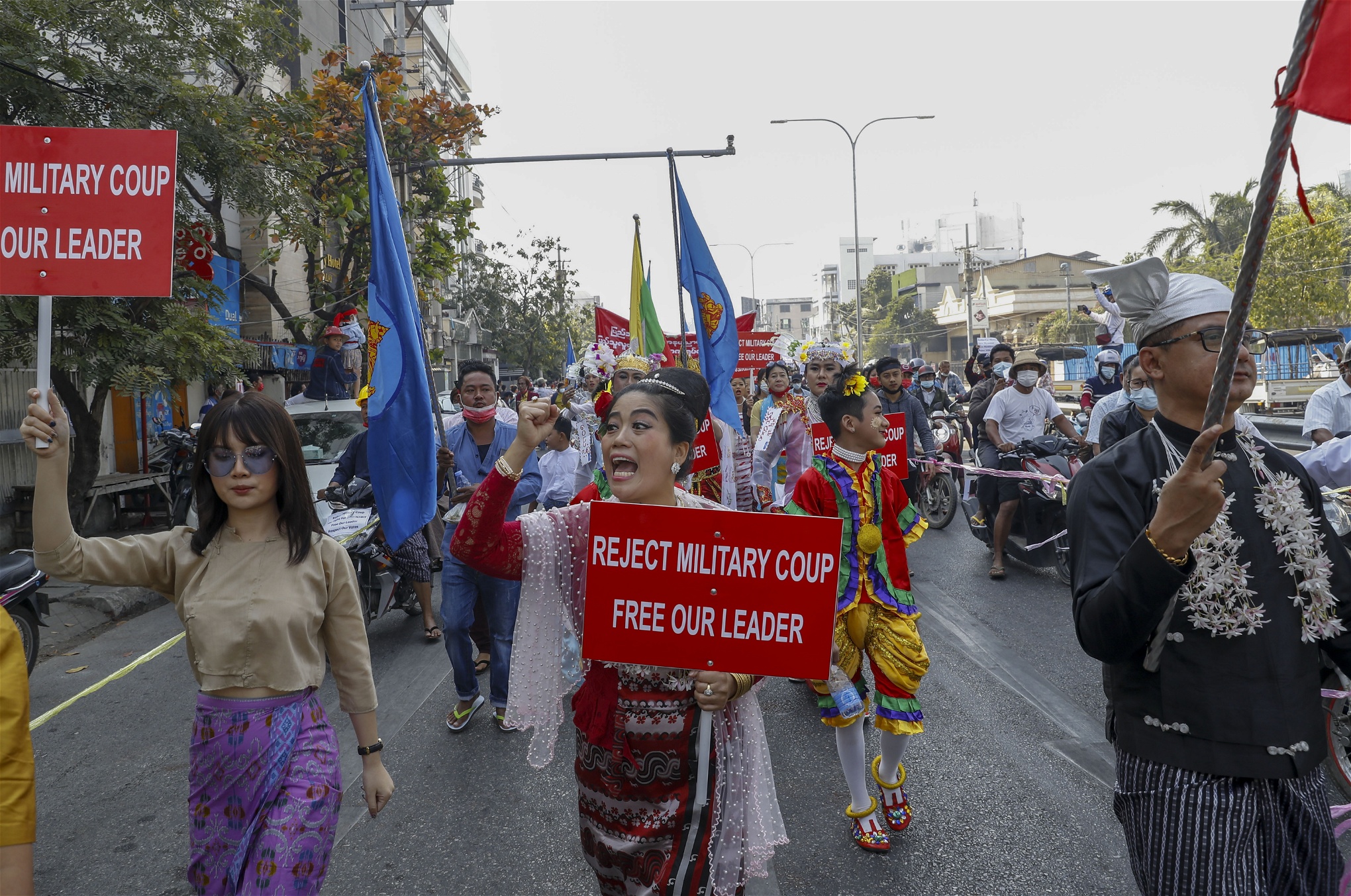 Demonstranter i Myanmar med skyltar med texten Reject military coup, free our leader.
