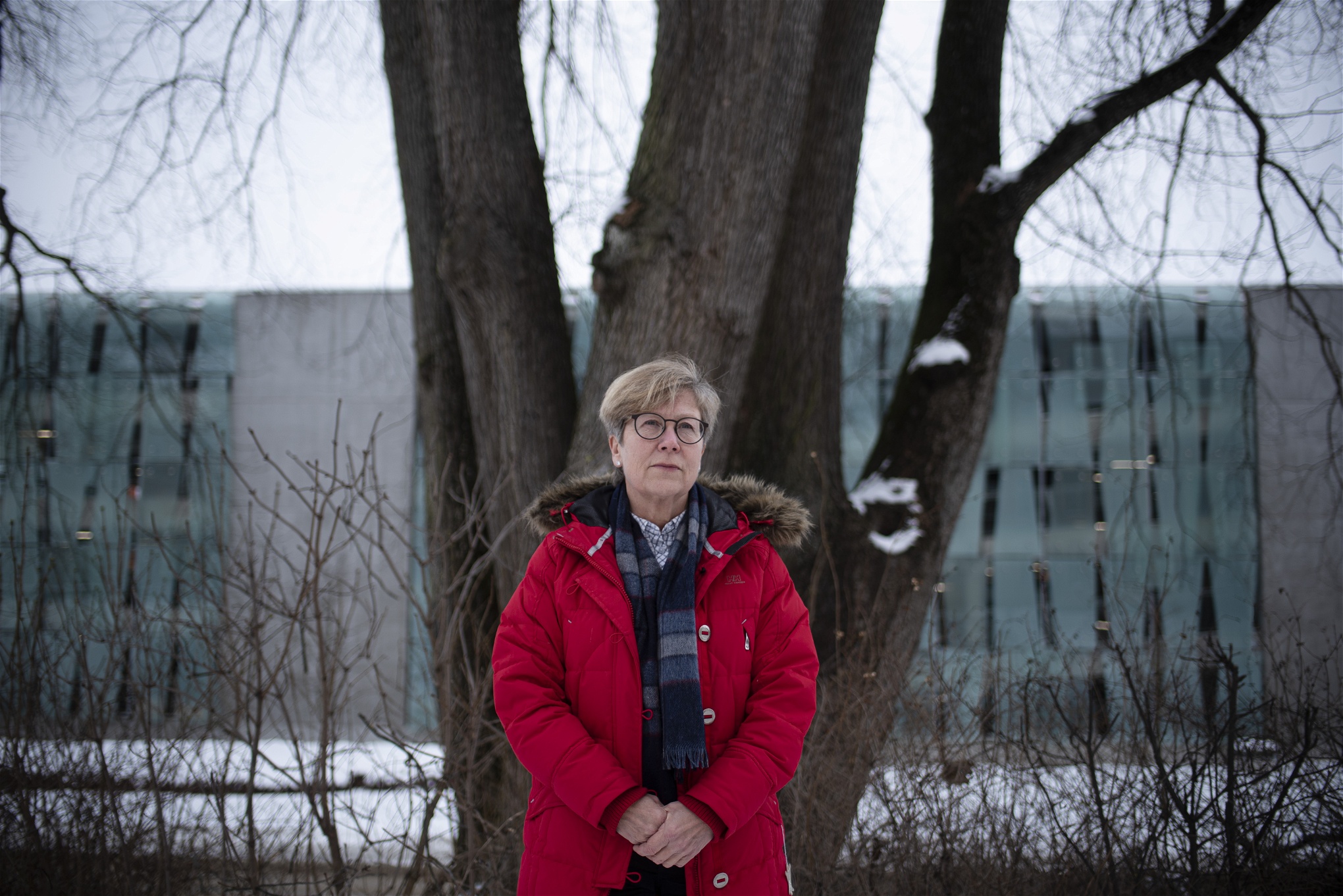 Åsa Witkovski på Nationellt centrum för kvinnofrid i Uppsala, i röd jacka framför ett träd.