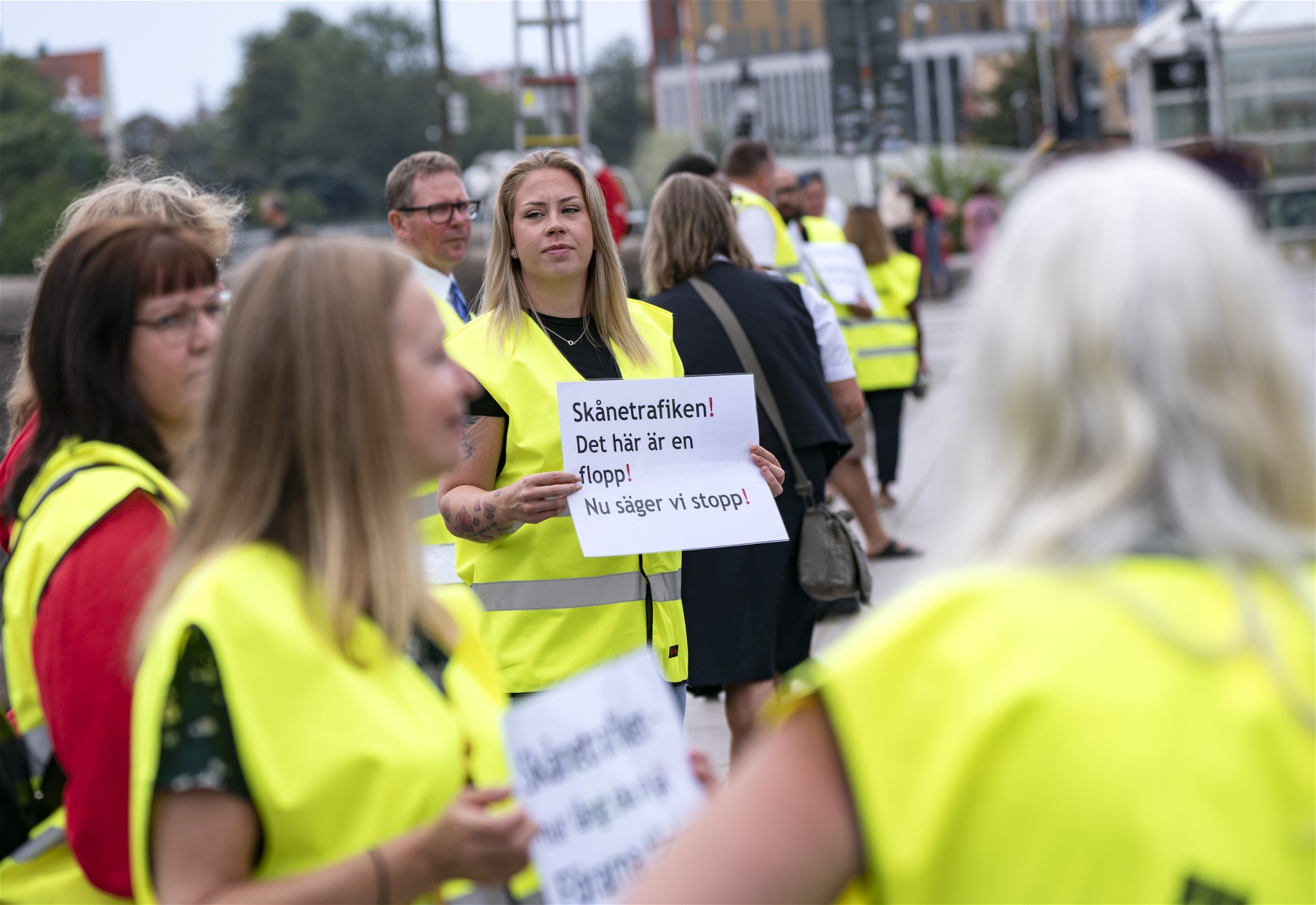 Demonstranter i gula västar och med skyltar mot Arrivas neddragningar på Pågatågen.