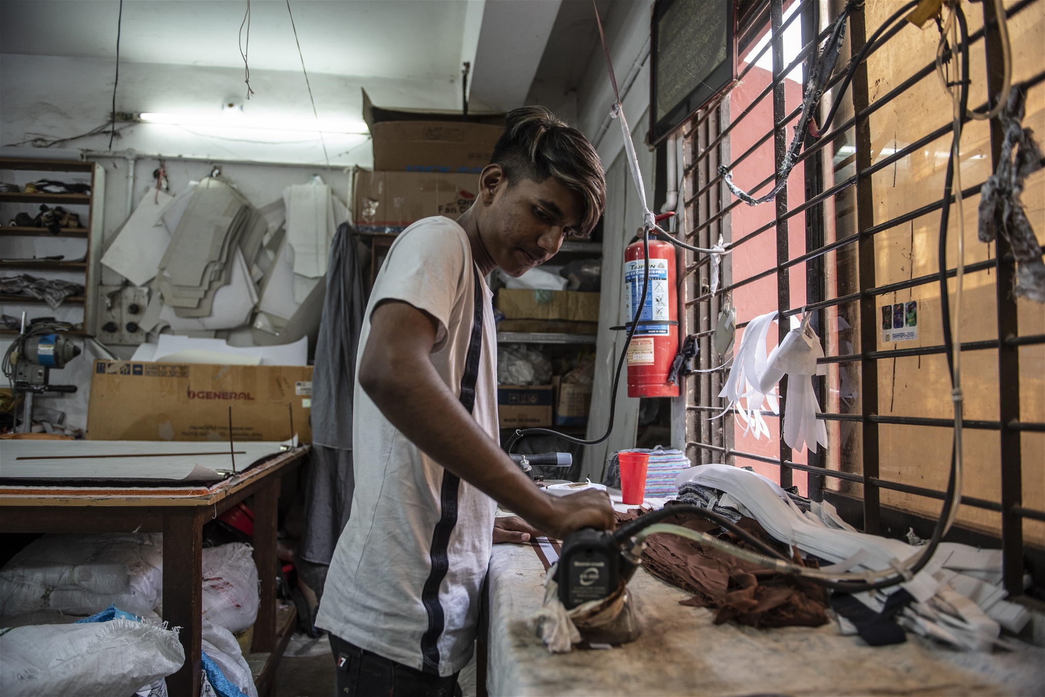 Sohel Sheik, 14, arbetar i en liten textilfabrik inne i gamla Dhaka. November 2019 Här jobbar han från morgon till kväll för att hjälpa till med familjens försörjning. Foto: Troy Enekvist 
