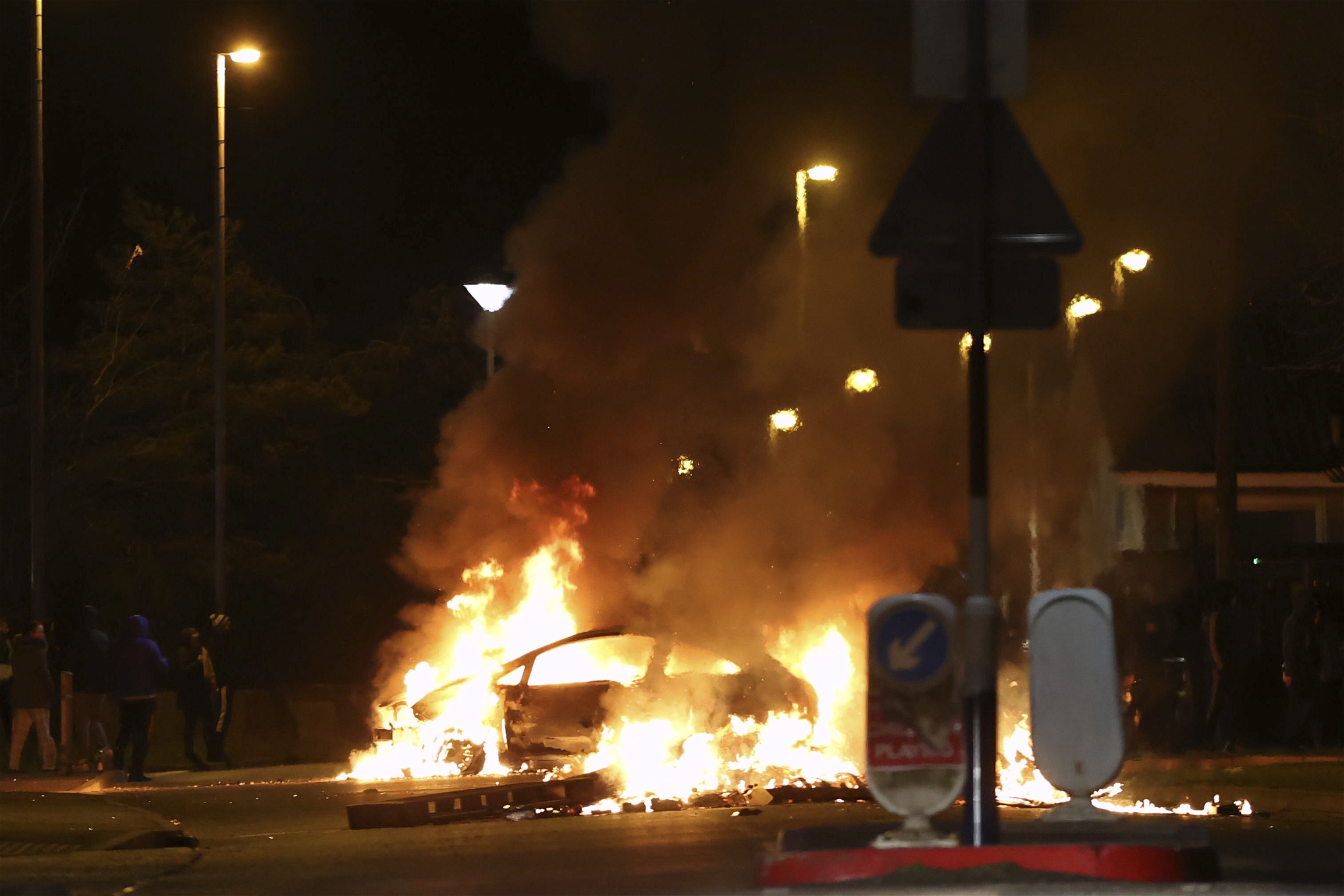 Bil i brand, under gatlyktorna i ett kvällsmörkt Londonderry.