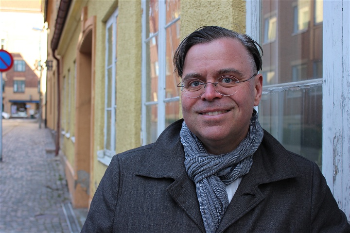 Ett foto på Andreas Önnerfors som står framför ett hus. 