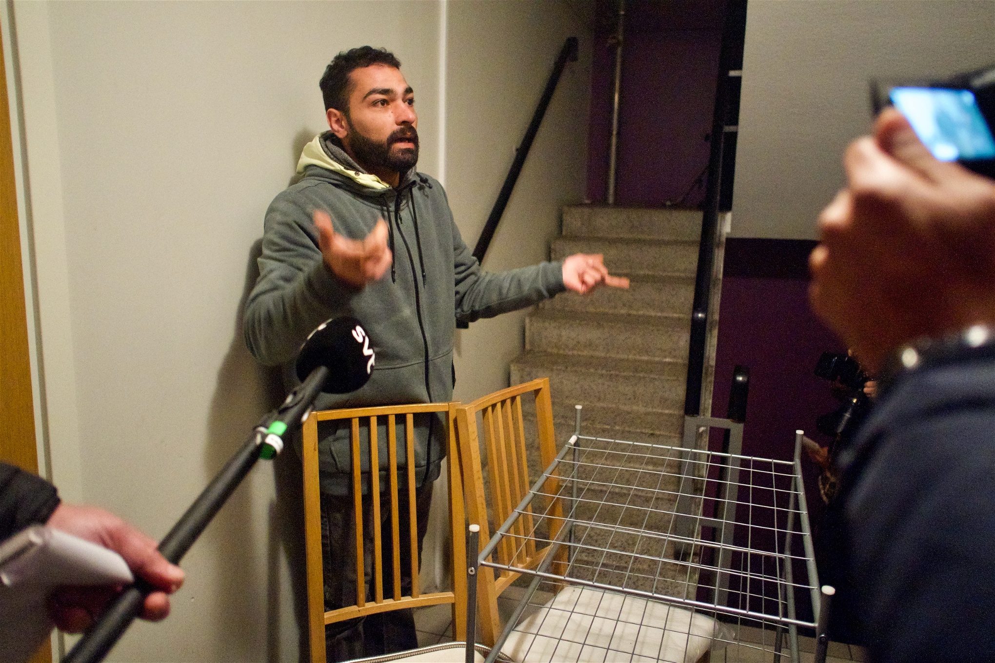 Hassan Zalha intervjuas av olika medier i trapphuset under den påbörjade vräkningen. 