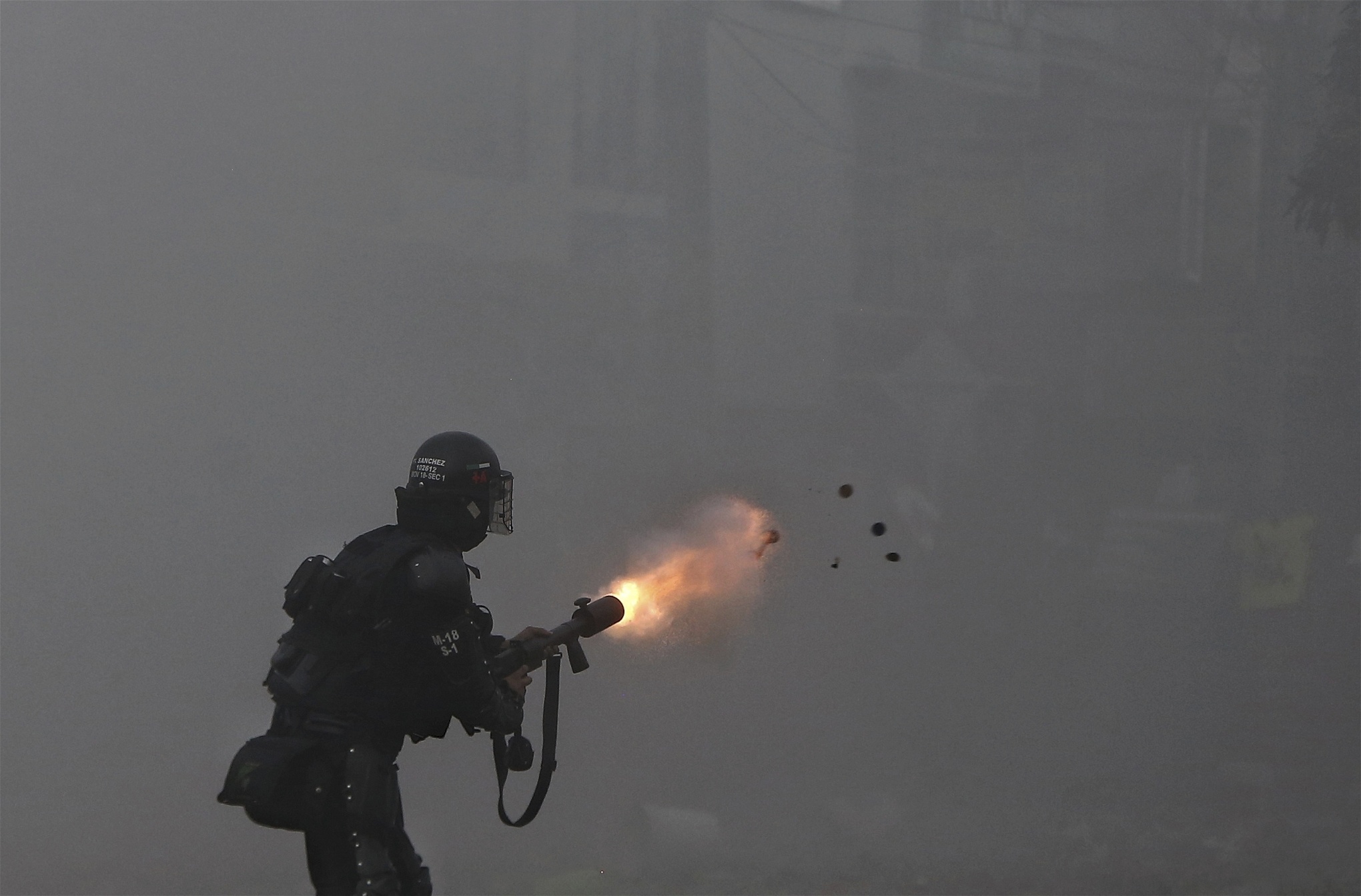 En polis skjuter tårgas mot demonstranter i Cali den 3 maj. Polisen har under åtskilliga gånger anklagats för grovt övervåld. Foto: Andres Gonzalez/AP/TT