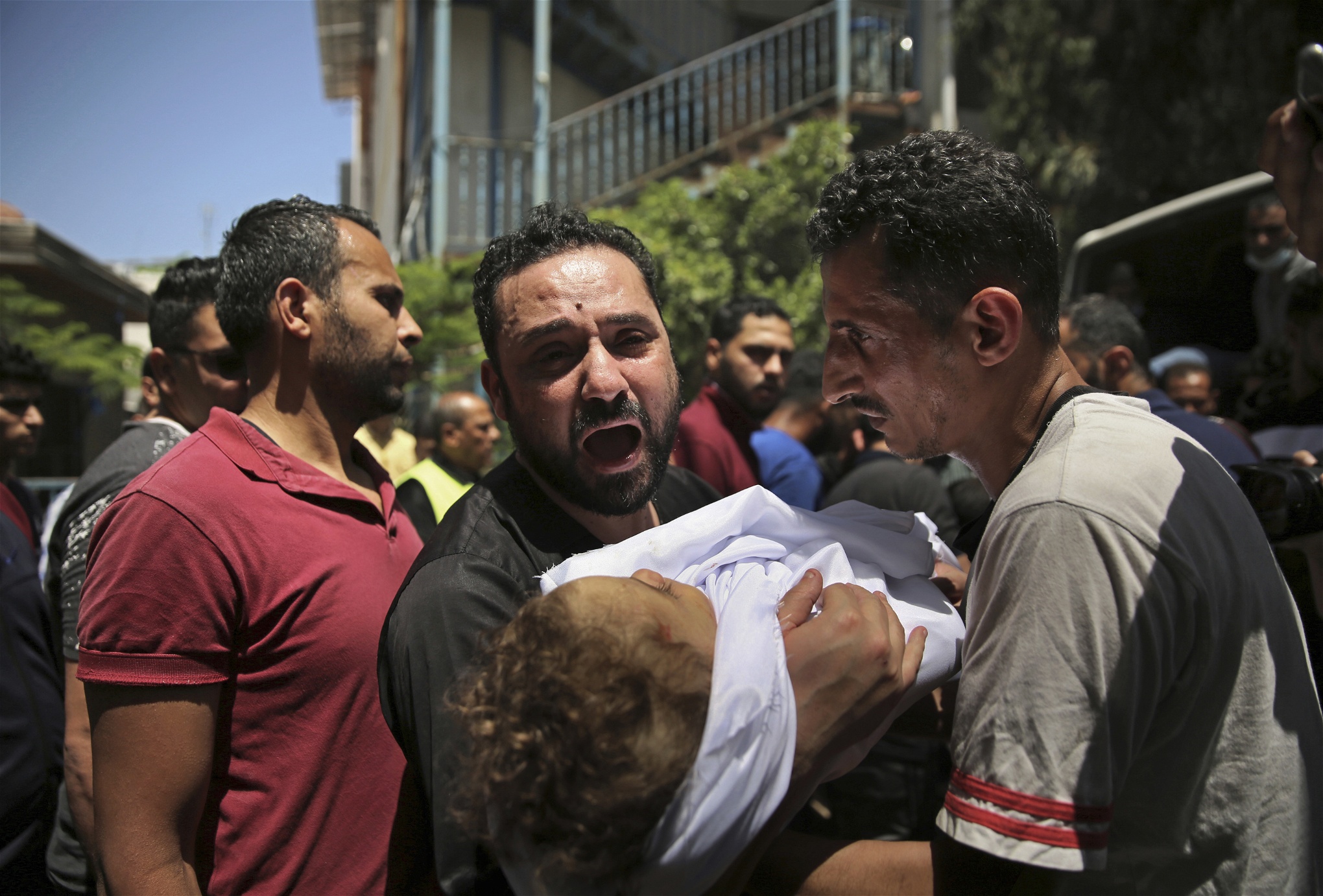 En palestinsk man i Gaza bär på ett barn som dödats i de israeliska bombningarna