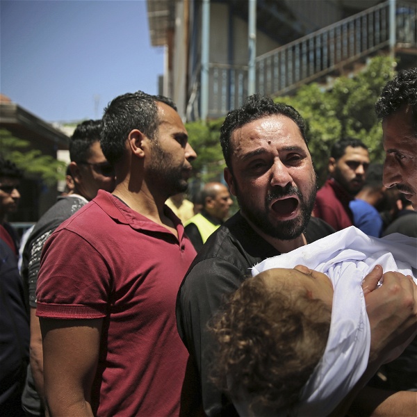 En palestinsk man i Gaza bär på ett barn som dödats i de israeliska bombningarna
